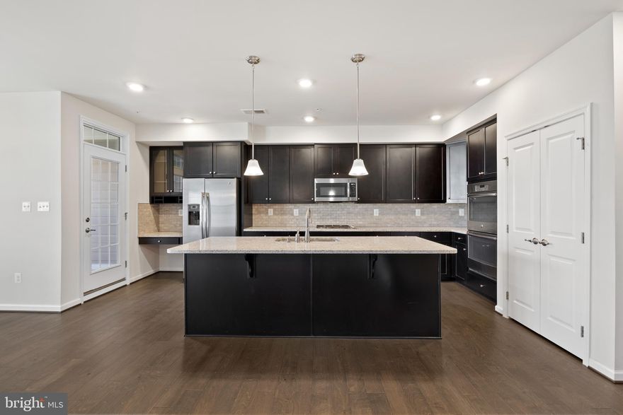 Welcome to this impeccably maintained townhome-style condo, boasting the Picasso model and constructed in ** 2018**. Nestled in the sought-after Discovery Square neighborhood, right in the heart of Herndon, this 3-bed, 2.5-bath, 1-car garage residence welcomes you with an inviting foyer that leads to a naturally light-filled main level. The main level boasts a beautiful gourmet kitchen with granite countertops, stainless steel appliances, a cooktop, wall oven, ample cabinets, pantry, and a family room off the kitchen. The living/dining combo provides a versatile space, and you can savor your evenings or private moments on the relaxing balcony. Hardwood floors grace the entire main level. Venture to the upper level, where two generously sized bedrooms with closets await, along with a hallway bath featuring dual vanities and a soaking tub. The laundry room offers stacked laundry and storage cabinets for added convenience. The spacious master bedroom steals the spotlight with a tray ceiling and expansive his & her walk-in closets. The master bath is a luxurious retreat with a soaking tub, standing shower, and separate his & her vanities. Conveniently located near restaurants and shopping, with easy access to Dulles Metro Rail, commuter routes, and the airport, this residence promises both comfort and accessibility.