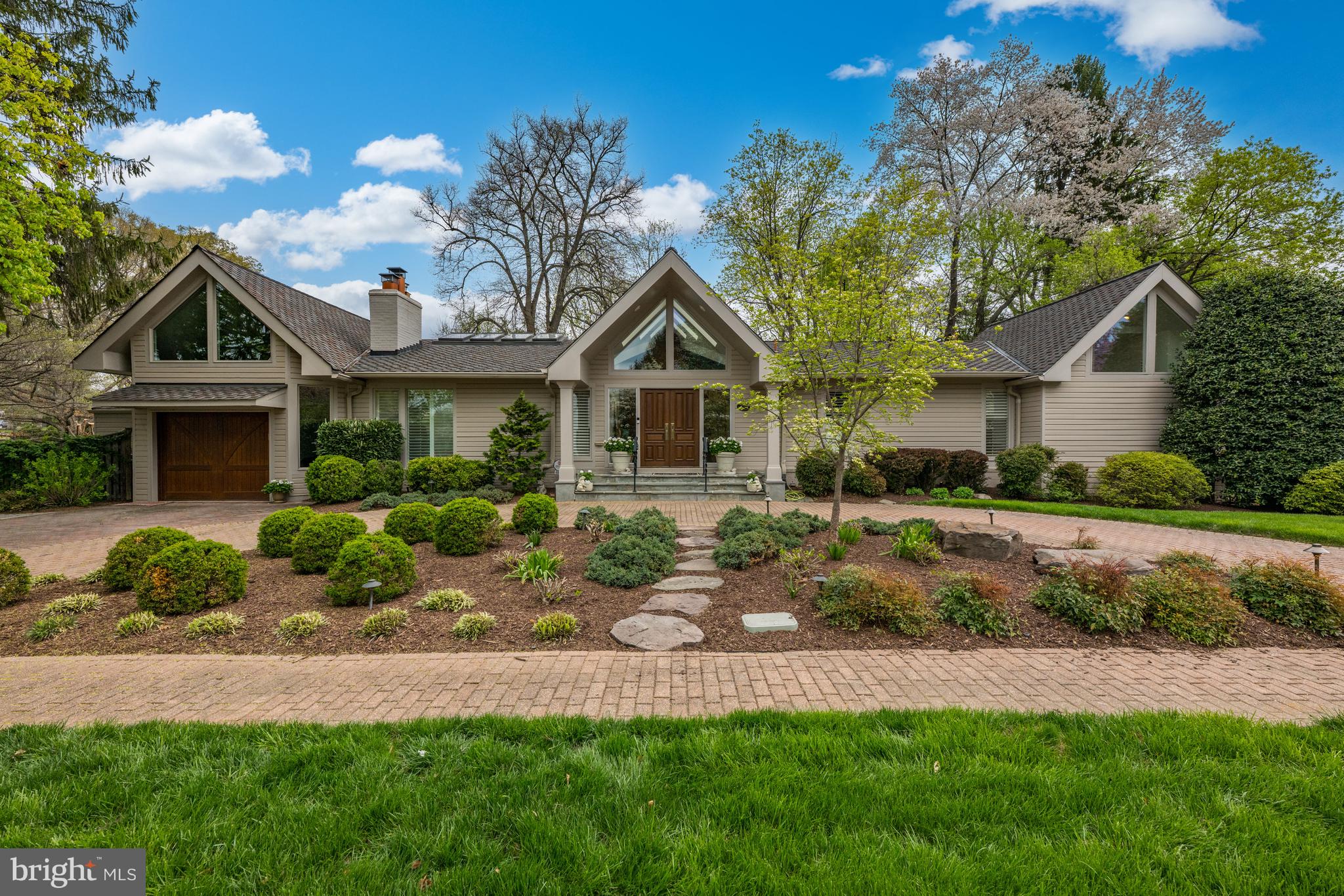 Prepare to be dazzled by this beautifully updated Craftsman-style home in Chevy Chase, MD! The beautifully landscaped grounds give you an indication of what awaits you inside. The covered entry 's double doors with glass side windows and triangular clerestory above open to the magnificent foyer with its vaulted ceiling and skylights, setting the tone for the magnificent, light-filled interior, which is ideal for large- or small group entertaining as well as comfortable family living. There are soaring ceilings throughout much of the main level; recessed lights; natural, reclaimed hardwood floors in many rooms; and plentiful windows offering views of the beautiful, landscaped grounds.
The main level offers an open floor plan, which is so popular in today's homes. The Living Room has a vaulted ceiling with skylights and a handsome wood-burning fireplace flanked by Open shelving and cabinets. It is adjacent to a large Dining Room with a cathedral ceiling and skylights, which in turn opens to a Solarium with cathedral ceiling, skylights, an extended window seat with windows and skylights above, and a sliding glass door to the extended Patio. The generous-sized Kitchen has plenty of space for the serious cook with plentiful white wood cabinets and a custom tile backsplash, stainless-steel appliances, a pantry closet, wet bar, and a sliding glass door to the solarium. A separate Sunroom also boasts a cathedral ceiling with skylights and opens to the Patio as well as the Garage.
The bedroom wing is where you will find the Primary Bedroom Suite. The Bedroom has two closets, attic access, a wall of windows, and sliding glass doors perfect for a future deck.
Prepare to luxuriate with two Primary Baths! The larger one features an aerated tub and an oversized tiled steam shower with built-in bench, large vanity, mirror with a hidden TV, a separate water closet, large, organized walk-in closet, and marble flooring. The second Bath, with vaulted ceiling and clerestory windows, has a marble pedestal sink with medicine cabinet above, ceramic tile shower with handheld and fixed showerheads, and a built-in niche, and ceramic tile flooring
The second Bedroom, which could also be used as a Study, has picture windows overlooking a Patio and the lovely back yard.
The finished walkout lower level features a spacious Family Rom with a wood-burning fireplace and built-in cabinetry on the side. This room has wall-to-wall carpeting.
Bedroom #3 has a wall of closets, sliding glass door to the Patio and an adjacent large Storage Room. Bedroom #4 has a trey ceiling, wall-to-wall carpeting and sliding glass door to the Patio as well. A full Bath has a vanity with medicine cabinet and sconces above, a fully tiled oversized shower with Raindance head and a second hand-held shower head, and tile floor. A Laundry Room and Utility Room complete this level.
The fully finished Garage has a separate Storage Room accessed from the Garage and Patio. The circular driveway of brick pavers provides lots of extra parking.
You will love the well-designed hardscape terrace, which has plenty of room for lounging, dining, and gathering around the firepit throughout the seasons.
Add to all this a wonderful location within walking distance to shops and restaurants on Connecticut Avenue, as well as proximity to Chevy Chase Lake, the Capital Crescent Trail, and the future Purple Line for the Metro. There is easy access to downtown DC with all its many attractions, as well as Bethesda and northern Virginia. Hop on 1-495 if you need to travel out of the area from any of the three major area airports.
This is truly a home for a lifetime!