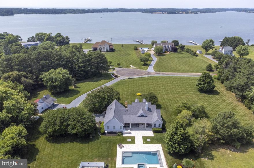 Exceptional 3 BR/ 2.5BA home built in 2001 and sited on 3.25 acres offering fantastic views of Harris Creek. Light-filled and open, this lovely home boasts cathedral ceilings and hardwood floors, gourmet kitchen with stainless appliances, office/den, separate dining room, and a large great room with gas fireplace opening to the beautiful covered patio. The primary suite offers complete privacy and the primary bath has double vanities, soaking tub, glass-enclosed shower, and walk-in closet. In addition are 2 guest bedrooms on the main level and a large bonus room upstairs which would make a great recreation room or bunk room. The back yard is gorgeous with its incredible 20 x 40 heated, saltwater gunite pool with waterfall, and attached heated spa! The outdoor kitchen with grill and refrigerator is conveniently located and surrounded by the large patio which is great for entertaining. There is a 2-car attached garage plus the large outbuilding with HVAC and 2 open sheds. Down the street is the community's shared dock and picnic area on Harris Creek and kayaks can be stored all year.  The community fee also includes arranging for and mosquito-spraying. Public sewer has also been approved for Indian Point West!