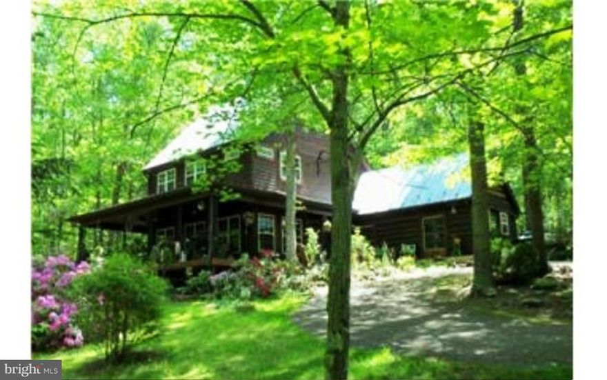 Lovely custom log home w/hand hewn logs. Huge wrap around porch surrounded by a beautiful, private, wooded 5 acresl with half acre pond.  HOA offers Fishing pond, Swimming pond, Tennis Courts, and Playground, and Picnic areas.  Two car garage w/workshop, 3 bay Machine Shed and so much more.