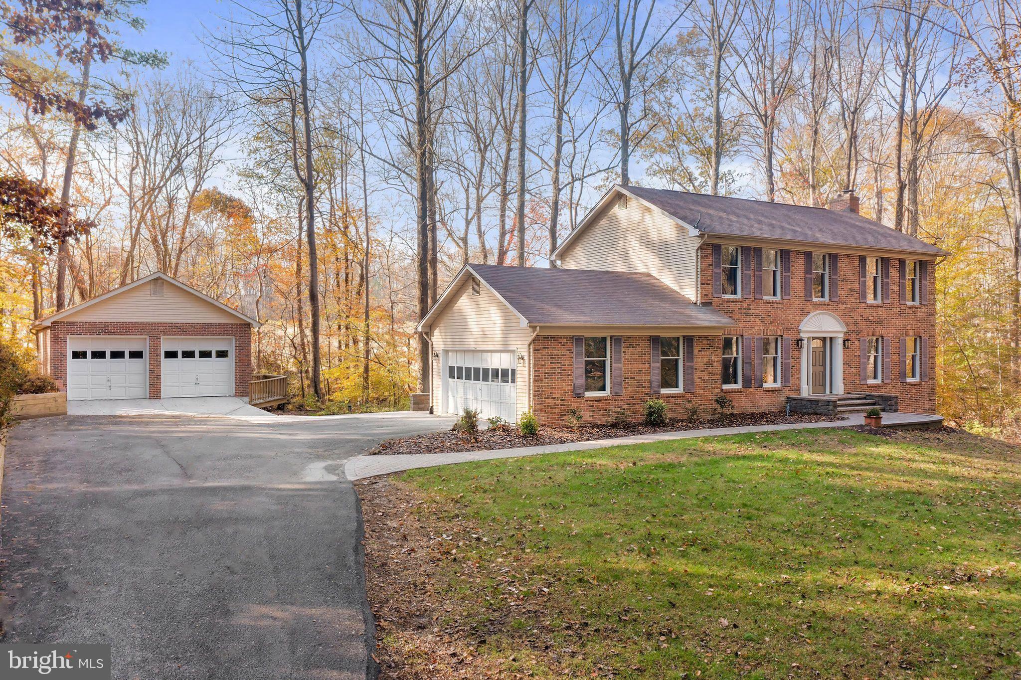 IMMACULATE, BRICKED BEAUTY WITH DETACHED GARAGE in the heart of Dunkirk, Calvert County, MD! LOCATION, LOCATION, LOCATION - this incredible home is located in the highly desired Smith's Purchase neighborhood and within the sought-after Northern High School District. Some of the home's outstanding features include 4 bedrooms, 2 full and 2 half baths, a renovated and open interior floor plan with updated kitchen, updated owner's bath, a stunning fireplace with marble hearth & gleaming hardwood flooring through out. A beautiful tree lined, paved asphalt driveway leads to nearly 3 acres of private, wooded property. You will be greeted by a fully bricked & oversized, detached 2 car garage and workshop. There will be plenty of room for parking with an extended turn around pad & an attached 2 car, side load garage. A curved leadway with stone pavers welcomes you to the wide front steps & porch entrance with newly installed front door & glass-lit windows on each side. As you enter the front door, you will notice the gleaming hardwood floors that run throughout the first floor, second floor & even the staircase! To the left is a formal dining room with plenty of space for seating & located directly off of the kitchen - the ultimate layout for entertaining. There is even a set of wood plantation doors for a private dining experience. To the right of the foyer is a wide open family room and entertainment space. The family room area is filled with beautiful, natural light. The anchor of this space is certainly the stunning, white, brick to ceiling, wood-burning fireplace with wooden mantle and marble hearth. Adjacent to the family room is the living room/sitting room where you can enjoy time with company, a cup of morning coffee or a game of cards. Centered on the back wall are a set of glass-lit french doors that lead out to an expansive, composite back deck with vinyl railings and an incomparable wooded view. Back inside, the kitchen is located off of the main living areas. The kitchen is spacious and updated with tiled flooring, stainless appliances, granite countertops and 42" designer cabinets with specialty pull-out drawers. Upstairs, the owner's suite is also spacious with hardwood flooring and an attached, private owner's bathroom. The owner's bath has been renovated with designer lighting, a custom vanity sink and a luxury shower with ceramic wall tile & frameless glass shower door. Down the hall, you will notice that the hardwood flooring continues throughout the second level and even into the secondary bedrooms. The hall bath has also been renovated with a stylish vanity sink, tiled shower and glass sliding shower door. Make your way to the lower level where you will discover additional rooms. Don't miss the pellet or wood stove rough-in in the finished basement recreation room! The main recreation room features a pellet or wood stove rough-in with a bricked surround on the floor and wall. In the recreation room, the owner's have also replaced the basement walk-out slider door with a brand new, extra wide sliding glass door. In this lower level space you can enjoy the built-in bar and a lovely wooded view from the level & walk-out basement exit. There is also a bonus room to the right of the staircase with double entrances. In addition to the bar, bonus room and pellet stove rough-in, the lower level also features a half bath & a storage/laundry room. This beautiful home sits on nearly 3 acres of private, scenic and wooded property - backing to farmland with picturesque views. NO HOA! 3428 Smithville Drive is situated on a very private home site, off of the street and surrounded by mature hardwood landscape. Schedule your showing today!