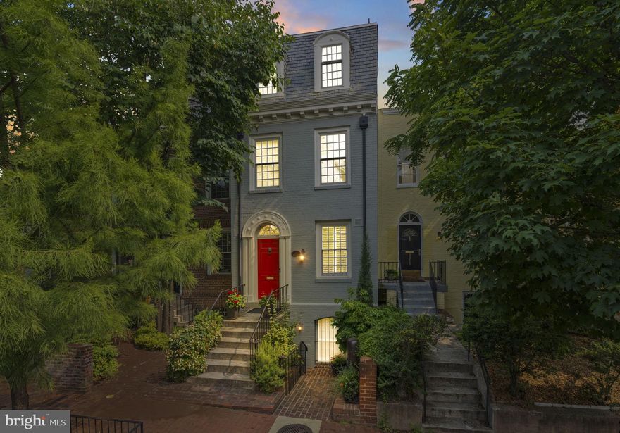 Built in 1942, this four-level Federal townhome in Georgetown’s West Village offers abundant natural sunlight and pristine original period details combined with modern updates throughout. The main level affords a spacious dining and living room with immediate patio access plus an updated eat-in kitchen with heated floors and plentiful storage. Upstairs, the formal living room provides hardwood floors, soaring ceilings, recessed and track lighting, a wood-burning fireplace, and floor to ceilings windows overlooking the rear garden. The fully-finished lower level offers a private front entrance, abundant storage and two gas fireplaces. Outside, the serene backyard affords a private garden oasis, designed by Guy Williams of DCA Landscape Architects. The outdoor sanctuary features abundant entertaining space across tiered flagstone, an underground sprinkler system and garden lights. Fresh paint throughout the home and a detached garage completes the offering. 3317 Dent Place NW is located just a short walk from Volta Park, Wisconsin Avenue, M Street and countless shopping and dining venues.