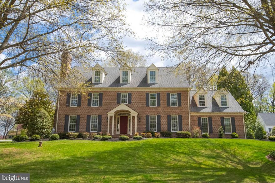 GORGEOUS, custom built Center Hall Colonial offers 5-6 BRs, 3/1 BAs, an oversized 2 Car Garage and is located in the beautiful Strathmoor community! Be transported to your own 'Slice of Heaven' with this stately, all brick home, situated on a slightly elevated hill surrounded by a manicured yard with mature trees. As you walk up the sidewalk, be captivated by the floral landscaping and peaceful neighborhood. Once inside, you'll enter the foyer with hardwood floors, wainscotting, chair rail and where you can enter the home office offering built-in bookshelves, wood floors and French doors and the formal living room offering crown molding, wood floors and a gas (propane) fireplace. From there, enter the formal dining room enhanced by gorgeous views of the patio and back yard, crown molding, wood floors and direct access to the gourmet kitchen and breakfast area which offers stunning cabinetry, high-end Jenn Air SS appliances, a downdraft surface stove (propane), wall oven/microwave that is convection and conventional, built-in secretary desk and granite countertops. The SUN-DRENCHED Great Room with fireplace, wood floors, French doors and crown molding is spacious yet gives a cozy, warm and relaxed feel. From the breakfast area, open the French doors to access the brick patio and large backyard framed by mature trees in rear and flowering bushes/trees on each side... did I say 'Slice of Heaven'? What a great yard for the kids and pets to plays in and large enough to add your own pool!  Back inside, walk up the hardwood staircase enhanced with wainscotting/chair rail to the second floor where you will find 4 BRs and 3 full baths. The large primary suite offers wwc, crown molding and custom window treatments. The spacious updated primary bath offers gorgeous cabinetry, granite countertops, twin sinks, a walk-in shower, soaking /jetted tub, water closet and large walk-in closet.  On the second floor, you'll also find a second bedroom suite with nook, crown molding, wwc, window treatments, and a private 3-pc bath with granite, a walk-in shower, plus a walk-in closet. The two remaining BRs offer wwc, crown molding and window treatments.  One floor up, find the Bonus Room/5th BR which the original owner created as a hobby room and offers ww Berber carpet, loads of storage, walk-in closet, extra storage and window treatments. The worktable conveys with home. Be creative! Make it an office, teen hang-out, an extra bedroom or child's playroom! Across the hall find the second Bonus room (Man Cave!) with wwc, walk-in cedar closet, extra storage behind smaller doors and window treatments which could easily be the 6th BR. The unfinished basement offers built-in equity to you and the opportunity to finish it exactly the way you'd like! SPECIAL NOTE: Windows/screens replaced in 2020 with Anderson Thermopane windows.  Third floor Bonus Room and Game Room add approx. 1,000 SqFt totaling 4,938 total above grade finished space. Original fireplaces were wood-burning and have been converted to propane gas which can be transitioned back to W/B should you choose. The architectural roof is 12 years old with a 15-year warranty. New washing machine installed 10/2024, new D/W and Cooktop installed 10/2020. Refrigerator/freezer in basement conveys. Sellers are graciously offering a Choice One one-year home warranty to the buyer. Truly the perfect, turn-key home in a beautiful community all close to schools, shopping, major highways and APG.