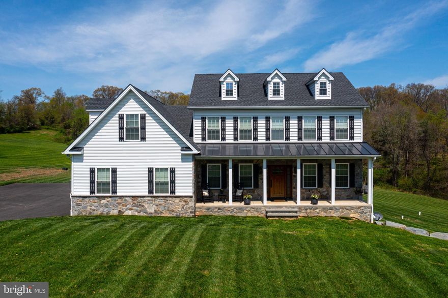 Welcome to this stunning custom modern farmhouse–colonial inspired residence situated on over 6 acres, offering natural beauty and gorgeous views. This exceptional home features 5 spacious bedrooms and 4 full bathrooms, thoughtfully designed for comfortable living and elegant entertaining. The main level showcases a warm and inviting living area centered around a charming fireplace, creating the perfect gathering space. The well-appointed kitchen includes a double oven, ample cabinetry, and generous workspace to accommodate all your culinary needs. The primary suite, conveniently located on the main level, offers a private retreat complete with a walk-in closet, a dedicated vanity area, and a full en-suite bathroom. Upstairs, a versatile bonus room provides flexible space ideal for a home office, media room, or recreation area. Additional highlights include a 2-car garage and expansive outdoor surroundings with wooded areas that enhance the property’s serene setting. This remarkable home blends classic Colonial charm with modern comfort in a peaceful, picturesque environment.