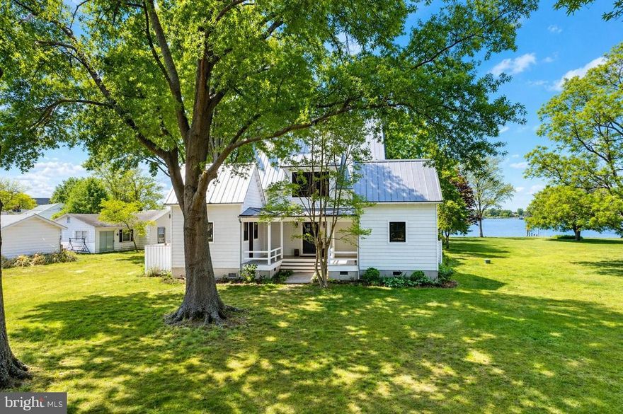 Welcome to an extraordinary Southern Living–inspired waterfront bungalow offering a rare blend of tranquility, luxury, and charm in pristine condition. Tucked away on a quiet, secluded road with only three homes, this exceptional property is surrounded by water and bordered by 25 acres of protected, unbuildable land, ensuring lasting privacy and breathtaking natural beauty.
Ideally located less than an hour from Annapolis, Baltimore, Washington, D.C., and Northern Virginia—including Alexandria and Arlington—this home provides the perfect balance of peaceful waterfront living with easy access to major metropolitan conveniences. 
The 4-bedroom residence features 2 full baths and 2 half baths, with an open, airy design that captures stunning water views from virtually every window. The main level includes two bedrooms and showcases soaring cathedral ceilings, solid wood doors, and exceptional craftsmanship, while thoughtfully preserved elements from the original cottage add warmth, character, and a sense of nostalgia. 
The spacious kitchen is both elegant and functional, offering Silestone countertops, stainless steel appliances, white cabinetry, abundant counter space, a breakfast nook, and radiant heated flooring, with propane gas fueling both cooking and the home's heating system. The inviting family room centers around a striking fireplace and flows effortlessly onto a generous wraparound waterfront porch—perfect for relaxing or entertaining while taking in serene views. 
Built with quality and durability in mind, the home features a metal roof, Hardiplank exterior, and a warm, welcoming ambiance throughout. This is a true waterfront lifestyle property, where fishing, kayaking, boating, and crabbing are part of everyday life, and where comfort, craftsmanship, and natural beauty come together in perfect harmony.