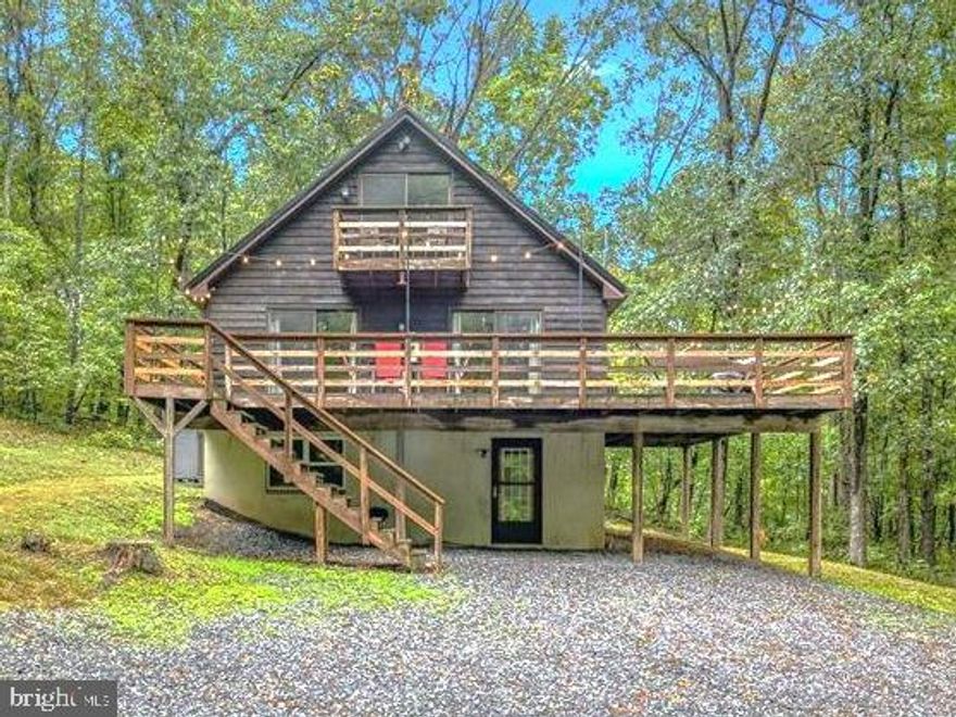 This beautifully renovated home with 2276 finished sq. ft. is perfect for full-time living or as a vacation rental, offers a serene retreat surrounded by trees. Renovated in 2022, it features a new metal roof and a fully finished basement with a luxury bathroom. The secluded property is accessed via a winding driveway through the trees.  Inside, you’ll find granite countertops in the kitchen, a great room on the main floor, and a family room on the lower level. On the main level the house has the great room, 1 bedroom, and 1 full bath, on the upper level are bedrooms and a half bath, and on the lower level there is a family room, a den, and a luxury bathroom. 
Outdoor amenities include a large deck and a fire pit, perfect for relaxing and enjoying the local wildlife, such as deer, turkey, foxes, and squirrels.  Located close to Berkeley Springs, you have easy access to dining and shopping. For outdoor enthusiasts, the nearby Sleepy Creek Wildlife Management Area offers hiking, fishing, boating, and hunting, while Cacapon State Park provides opportunities for hiking, swimming, and horseback riding. Additionally, Harpers Ferry, WV, is a great spot for sightseeing.