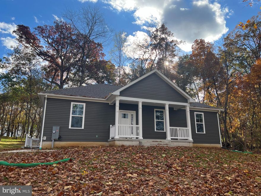Photos are current as of 10/31! Finshed and ready for move-in!  No HOA on 1.3 unrestricted wooded acres minutes outside of Shepherdstown! One level ranch home hosting split bedroom plan with three bedrooms and  two full bathrooms with open living/kitchen/dining layout.  Kitchen will boast white cabinets, island, granite countertops, and stainless appliance package.  Open living/dining space with cathedral ceilings and main living area w/ LVP flooring selection and electric fireplace.  Primary bedroom suite offers walk-in closet and full bathroom w/ tiled walk-in shower.  Full unfinished  basement offers space for future growth! Enjoy sipping sweet tea from covered front porch.  Just minutes from the conveniences of town w/ shopping, restaurants, and medical facilities nearby. Purchaser responsible for paying transfer tax stamps.