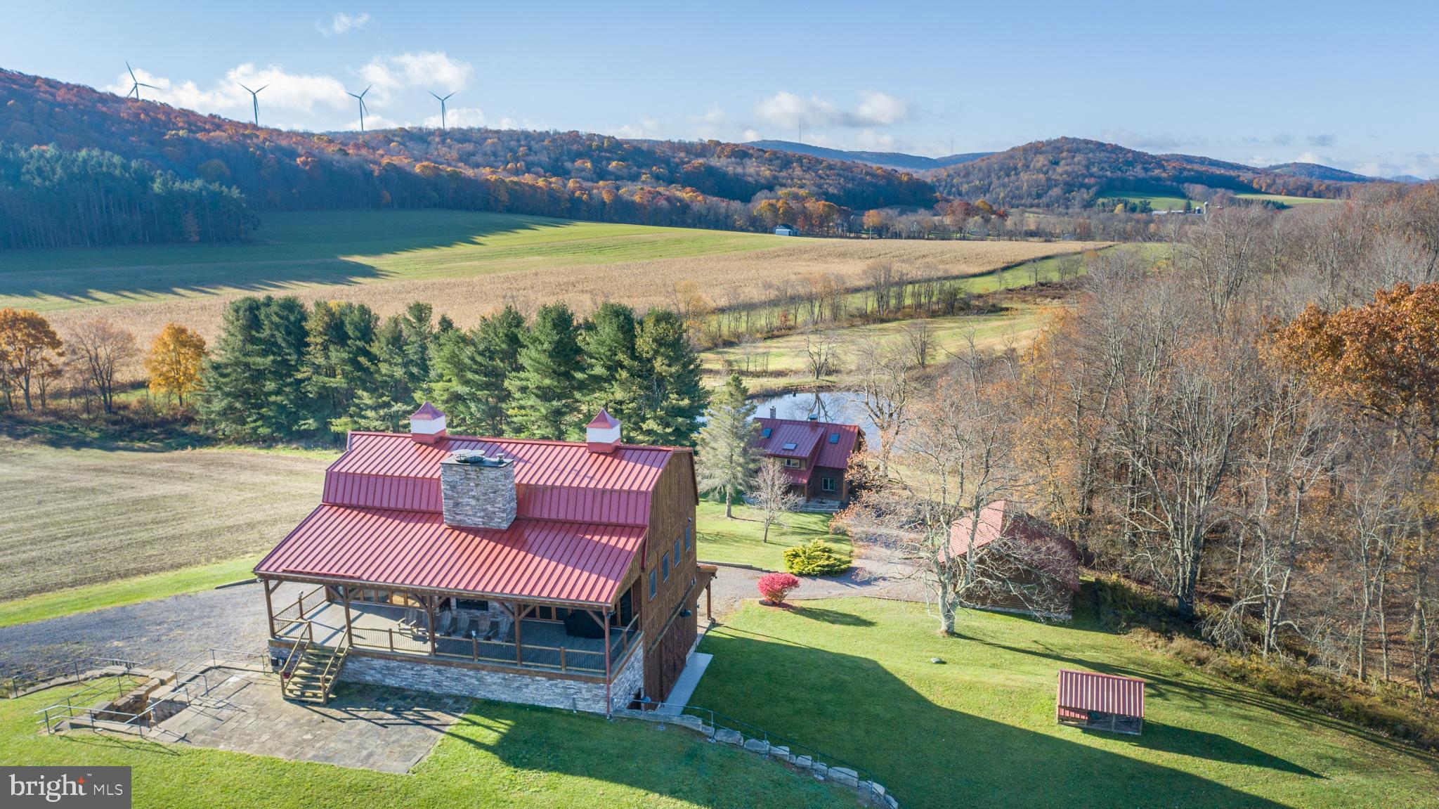 Experience your own slice of paradise in the highly desirable Pleasant Valley area of Garrett County. This scenic 3-bedroom log home overlooks a serene private pond, nestled on 22 breathtaking acres that blend open pasture with peaceful wooded areas, all with stunning mountain views. The property boasts a 2-car detached garage and an impressive, upscale barn with a spacious workshop, offering endless possibilities for your hobbies or business ventures. Above the workshop, you’ll discover a stunning entertainment area perfect for hosting gatherings. Featuring a stacked stone fireplace, a kitchen and bar area, a game room area, and a loft for additional sleeping space, plus a full bathroom, this area is built to impress. Currently operating as a small farm, including a fully fenced in pasture (electrified) to include a lean to with a spring fed trough for animals to graze in. This property offers a unique blend of luxury, functionality, and tranquility. Truly a must-see, this property has everything you’ve been searching for. Schedule your appointment today and step into the lifestyle of your dreams!