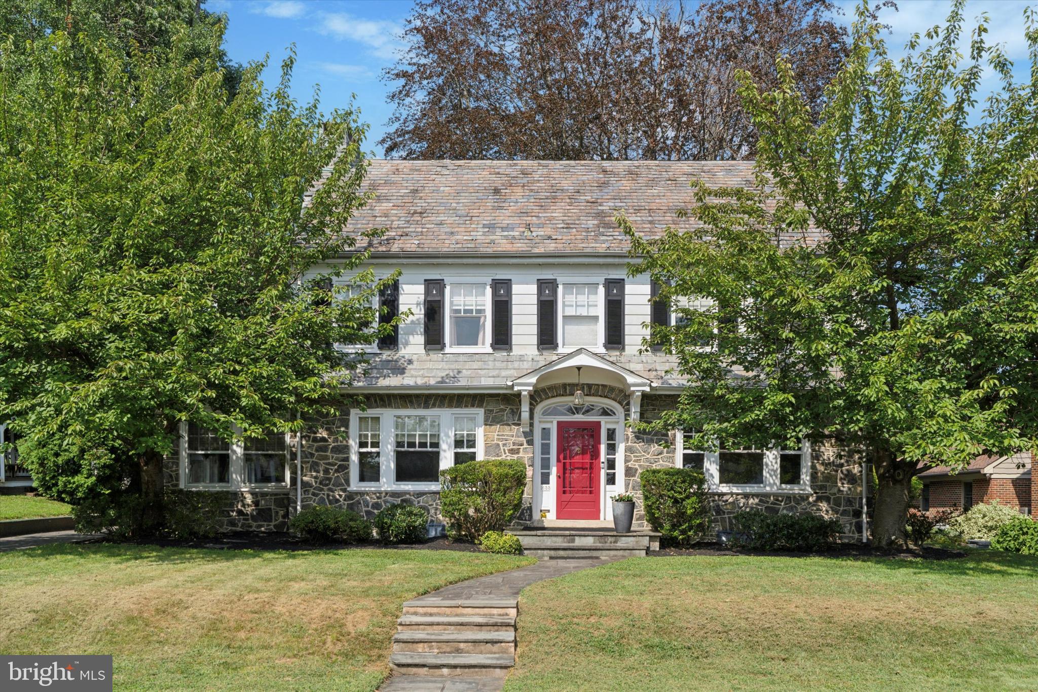 Spectacular 6-bedroom, 2.5-bath Stone Colonial in the highly sought-after Halford Tract of Jeffersonville! This timeless home offers classic stone architecture and outstanding curb appeal, highlighted by mature landscaping and flowering trees. Inside, rich details include inlaid hardwood floors, wide doorways, custom millwork, and deep-set windows. The spacious main level is designed for both entertaining and everyday living. A gracious living room anchors the home with a cozy electric fireplace and French doors that open to a bright four-season sunroom. The formal dining room, accented with crown molding and chair rail, flows seamlessly into the beautifully remodeled kitchen featuring 42” cabinetry, granite counters, stainless steel Jenn-Air double ovens, and GE appliances. A convenient half bath completes the first floor. Upstairs, the primary bedroom features hardwood floors and custom trim, while three additional bedrooms offer generous space. The renovated full bath impresses with Kohler fixtures, Porcelanosa finishes, and Calcutta marble. The finished third floor adds two more bedrooms and another full bath—ideal for guests, home offices, or a private suite. Outside, enjoy the oversized patio, cedar fencing, and tree-lined yard that create a private setting for entertaining, gardening, or play. A detached two-car garage with attic storage, long driveway with turnabout, and garden shed provide added convenience. All this in a vibrant community with easy access to major highways, regional rail, and the Schuylkill River Trail. A truly one-of-a-kind home that perfectly blends historic charm with modern updates!