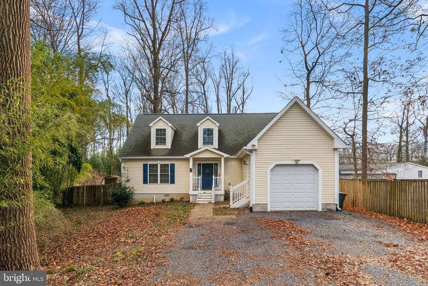 Built in 2008, this Cape Cod sits on a third of an acre in the water-privileged community of River Club Estates, set well back from Central Avenue, and buffered by mature trees, bamboo, and conservation land along the side of the property.  Gravel driveway fits three cars comfortably, up to eight for gatherings.
Nine-foot ceilings on the main level. The living room features new luxury vinyl plank flooring (2025), gas fireplace with decorative mantel, and dentil crown molding, and fllows into the dining room, new atrium doors with integrated between-the-glass blinds open to a deck overlooking the fully fenced backyard.  Kitchen highlights: maple cabinets, granite counters, center island with stool seating, accent wall, tile flooring, crown molding, brand-new Samsung Bespoke refrigerator.  Half bath and laundry on the main level.   Three bedrooms, each with its own full en-suite bath - a rare layout. The main-level suite has two closets (one walk-in, one with full organization system) and a spa soaking tub. The two upper-level suites each have walk-in closets and full baths, rooms large enough for a king bed and home office in each.
Fenced backyard with Amish-built storage shed.  Garage has floor-to-ceiling shelving on one side, still fits a large SUV.  Major systems current: HVAC (2021), well pump and water lines (2021), gutters and trim (2025), atrium doors (2025). Termite-treated and certified.  Over $75,000 in documented improvements.
Five minutes for groceries.  Central to the DMV.  Easy access to Fort Meade, Annapolis, DC, and Baltimore.
Residents of River Club Estates can enjoy optional amenities through a voluntary HOA for just $75 per year, including access to a sandy beach, dock, picnic tables, watercraft rack, and benches, perfect for enjoying the waterfront lifestyle.