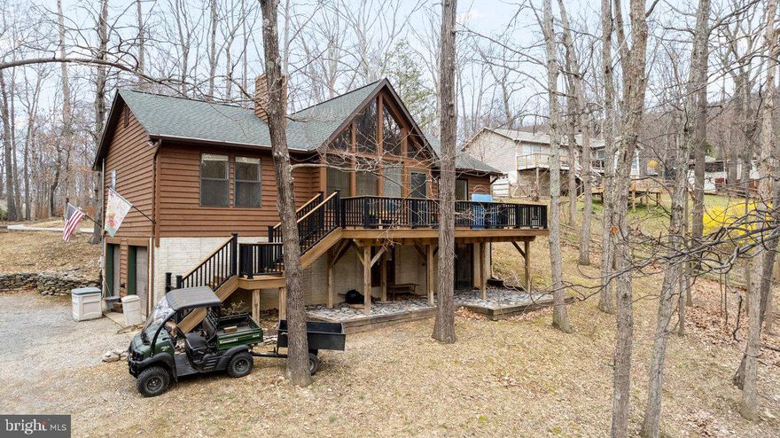 Welcome Home! This beautiful gable front, cedar siding home offers you relaxation with interior features & outdoor ammenities.  One Level Living. So well maintained with newer roof, HVAC, updated kitchen & bathroom & flooring.   You'll love your open Great Room with wood flooring, pine cathedral ceiling, a stone front wood burning fireplace with mantel , ceiling fan and surround sound.  Enjoy all the sunlight from your wall of gable windows & sliding glass doors!  Adjacent to the great room, you'll love your culinary experience of  your newly remodeled gourmet kitchen:  with black stainless appliances, a French Refrigerator w/ ice maker & conversion drawer, smooth top range with double oven, convection,  built in microwave, enamel farmhouse sink w/gooseneck touch faucet,  dishwasher,  Craftsman Shaker style cabinetry with pull outs & glass front displays, quartz counters, undermount lighting & recessed lights, pantry plus a pantry cabinet,  pull out wastebasket/recycle cabinet and glass tile surround.   The Owners Suite with new carpet & new sliding glass doors to the front deck and a  private updated  bath:  new tub/shower, vanity/sink, a 360 flush toilet and tile flooring.  Split floor plan with seconday bedrooms on opposite side of the home wih an updated hall bath w/ wainscotting & tile.   Unfinished basement that's heated & cooled for your future rooms or workshop, studio, with a rough plumb for adding another bathroom. Saltless Apec water filter system, generator, linen closet, coat closet, laundry hookup, ADT security system, Xfinity internet & cable TV,  landline phone hook up.   With 7 home sites combined, this property is a total of 1.34 acre size.  Plenty of room for your outdoor living spaces:  a  30 ft front Trex deck with vinyl posts & a stair gate, a 26 ft wood back deck, a lower level patio,  retaining walls for landscaping, front yard for fire pit, gardening, yard parties.  Storage aplenty:  2 car garage,  large storage building on foundation/crawl space with electric,  2 medium sheds (one with electric) and one outbuilding with fencing for chickens or as a dog or goat kennel, also with electric.  Gravel driveway for lower parcels and stamped concrete driveway for upper yard, plenty of off street parking .   Convenient to tri state & DC commute routes 340, I.270, Rt 9, Rt 7 and Marc Train.  Minutes to Charles Town, retail, schools, dining.  Nearby Harpers Ferry National Historic Park at Potomac & Shenandoah Rivers,  Maryland Heights & Boliver Heights & Appalachian Scenic trails, Sweet Run State Park, kayaking, fishing, art galleries, downtown boutiques, Hollywood Casino horse races & concerts, wineries & breweries.  No HOA . Community offers optional  membership to  Mountain Lake Club with restaurant, events, a 55 acre lake for swim, fish, boat.  This move-in ready beauty wont last long. Call today for your private showing appointment
