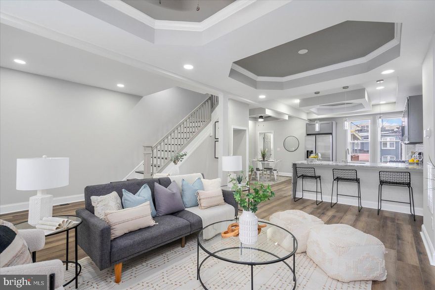 A stunning transformation has taken place behind the door of this 4BR/3.5BA brick Townhome located on a quiet street in Baltimore City.  Make your way through the gated front yard, pass by a lush lawn on the way to the covered front porch of your forever home.  The luxury begins as you step into a beautifully designed main floor featuring custom coffered ceilings , luxury flooring, and recessed lighting throughout the open floor plan.  The spacious living room offers a feature wall hosting a gas fireplace feature with custom built in shelving.  The stunning kitchen and dining room are ideal when hosting family and friends.  The kitchen features plenty of cabinets, stainless steel appliances, granite countertops with a complimenting tiled backsplash, and a stainless sink set into the peninsula with a waterfall edge, pendant lights and breakfast seating for three.  Just beyond the dining room is the main floor laundry and a half bath. The newly carpeted second floor offers two sizable secondary bedrooms, a newly remodeled full bath, and a primary suite.  The spacious primary boasts a private en suite featuring a beautifully tiled walk-in shower. The lower level is finished offering additional living space beginning with new carpeting, the fourth bedroom, a full bath with walk-in shower, a large family room with space for everyone, and a walk-out to a Bilco door in the yard.  From the main floor step outside onto a large wood deck with a covered awning that overlooks the fenced yard offering green space and so many possibilities.  No attention to detail was missed during the creation of this stunning home making it the ideal home for any new homeowner.  Imagine all this and in close proximity to shopping restaurants, and commuter routes.