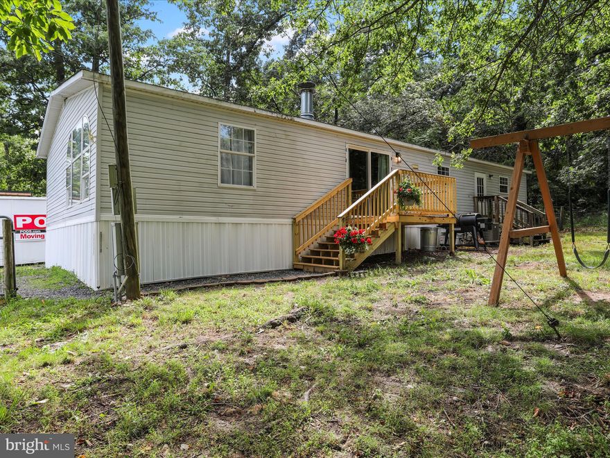 ***Professional Photos Are Pending***

Nestled in the peaceful countryside, this charming manufactured home offers the perfect retreat from the hustle and bustle of town. Surrounded by wide open spaces and serene views, the property blends comfortable living with the beauty of a rural setting. Inside, you’ll discover a thoughtfully updated layout featuring three bedrooms and two full baths, including a private ensuite. The spacious living area invites you to unwind by the warmth of a wood-burning fireplace, creating a cozy focal point for relaxing evenings at home. The  kitchen comes equipped with a refrigerator and oven/range, both only three years old, ready for your favorite recipes. Several recent improvements ensure you can move right in with confidence, including a new well pump installed in December 2023, a newer heat pump and air handler added in 2020, and fresh deck boards perfect for taking in the tranquil views. Step through the new sliding glass door onto your deck and enjoy the fresh country air. Stylish new LVP tile and updated flooring in the bathrooms complement the brand-new bathtubs and shower stall. With 200-amp electric service, a washer and dryer just five years old, and modern finishes throughout, this home combines rustic charm with everyday convenience. All you need to do is move in and start enjoying life surrounded by nature and open skies.