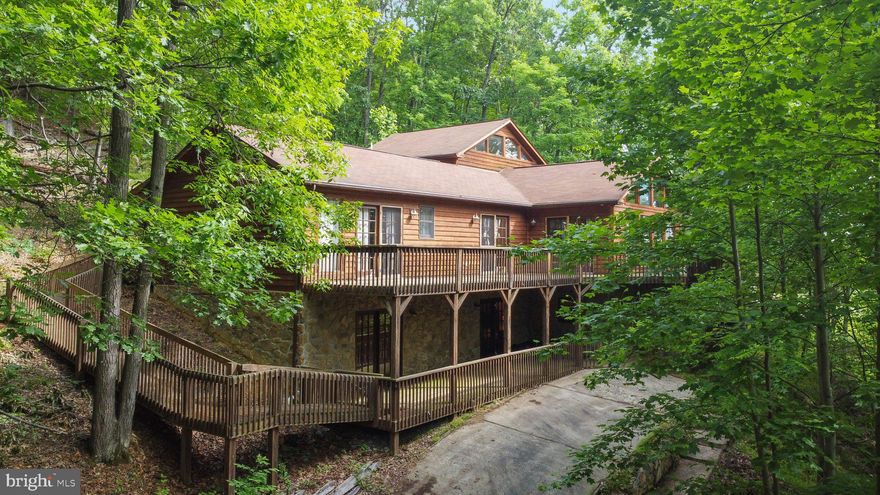 Beautiful Contemporary with many upgrades, making it a unique, quality built home.  The lowest level  features a spacious Family Room with a wood burning fireplace, 2 spacious bedrooms, each with private bathrooms  and access to lower deck.    All flooring on lower level is cement coated wood planking.  The main level features a stunning  Great Room with a wall of windows to enjoy the seasonal mountain views.   Open great room, dining and kitchen floor plan provides an inviting entertaining area.  Kitchen features red silestone counter top and custom cabinetry.   Owners bedroom and adjoining bath with a double sided wood burning fireplace ensures a quiet oasis.   An additional bedroom and bath are situated on this level.   Flooring on this level is 3/4' prefinished wood.   All rooms on this level have access to a wraparound upper deck, which leads to a gazebo.   Upper loft area features a 5th bedroom and bath overlooking the great room.     Situated on 4.45 Acres in Coolfont Mountainside, which backs to Cacapon State Park. Whether living at the home full time or as a retreat, the  Coolfont community offers amenities,  making your time an enjoyable oasis.   Only 7/10 of a mile from the tenns court, hot tub overflowing into the inground pool, bath house, and  playground area.  Other nearby attractions include a renovaed barn, which can be leased for large gatherings, Tnewly renovated Treetop Restaurant and indoor pool /spa as well as a brewery.   Located just minutes from the newly renovated Cacapon Resort State Park for outdoor activities. Today, the park encompasses 6,115 acres and includes the 130-room lodge with restaurant, 50 year-round cabins, a 6-acre lake, picnic/shelter areas, and 27 miles of hiking trails. A riding stable is also on the property. The  Old Inn  houses twelve to fourteen people for reunions or special events  Recent renovations added a new indoor/outdoor pool, a spa and fitness center, new public dining room, and updated kitchen. The Robert Trent Jones, Sr. designed golf course is considered one of the finest in the East. Voted USA Today’s Top 10 Best Small Southern Town in 2015, Berkeley Springs is a historic spa and art-filled town nestled in the West Virginia mountains only 90 minutes from the Washington/Baltimore metro area. It boasts warm mineral springs, world-class dining, blocks of distinctive shops, full-service spas and more than 100 lodging choices, from elegant B&Bs and historic inns, to cabins and resorts. Golf, hiking, biking and swimming share the schedule with year-round festivals, live music and theater. Friendly people, welcoming mountains and a sense of place mark Berkeley Springs as a getaway for all seasons and tastes