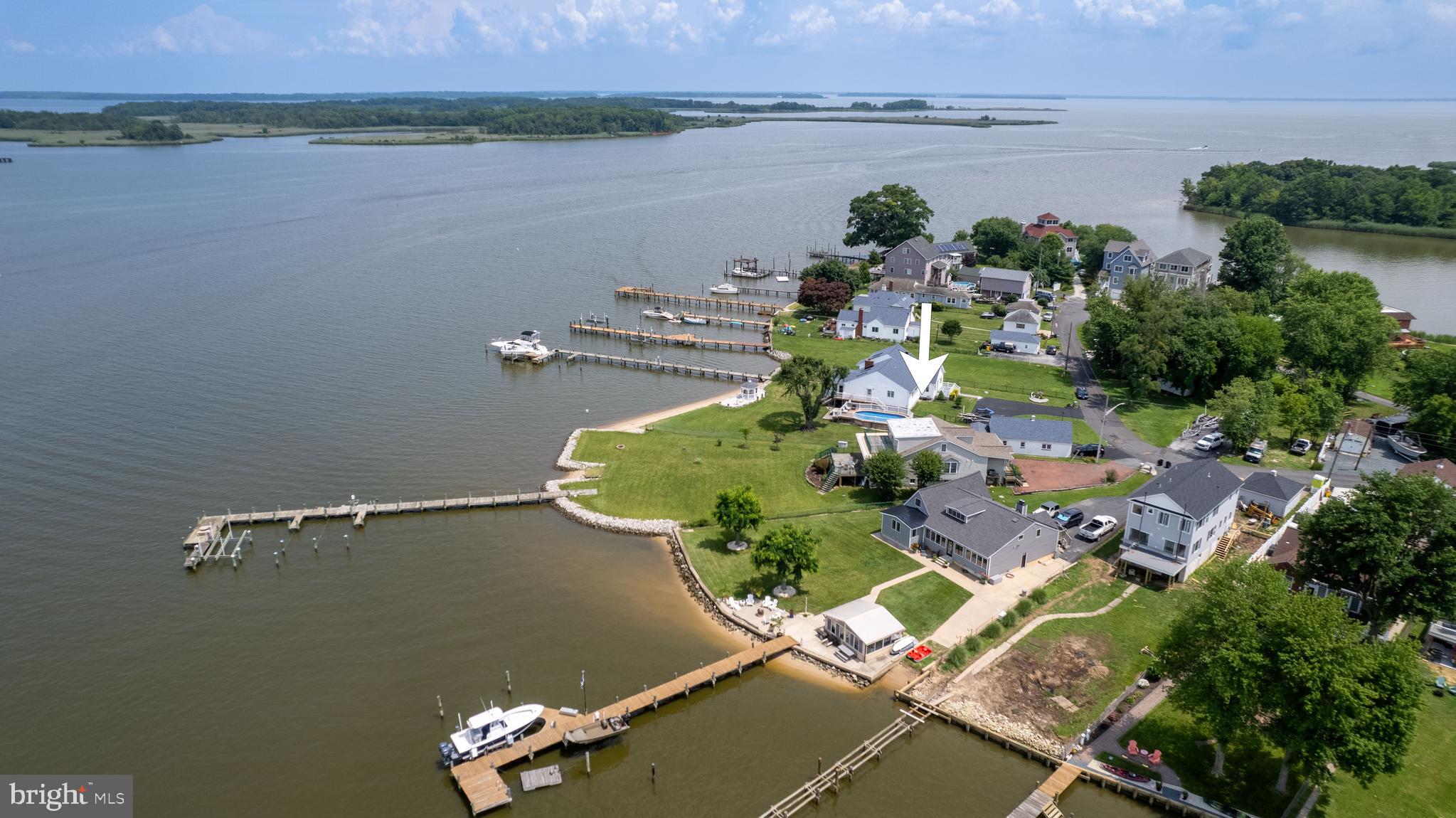 WE HAVE RECEIVED MULTIPLE OFFERS please submit highest and best by noon on Tuesday 7/11/23. Panoramic views, extra deep water, open floor plan – what a find! Located on a quiet peninsula at the mouth of Seneca Creek which opens right into the Chesapeake Bay, this 4BR, 2.5BA 2400 sq ft waterfront home in Bowley’s Quarters is your ticket to paradise. The kitchen, living and dining areas are surrounded by an expanse of windows bringing in tons of natural light with views from all angles. Speaking of views, there are decks on the first and second level! Some of the many features include: main floor primary bedroom with en-suite bath and walk-in closet, beautiful hardwood floors throughout, formal dining room or den/office, main floor laundry room, huge unfinished lower level, ramp/beach area, huge pier with boat and jet ski lift as well as two finger piers, sandy bottom 10+ ft depth, half acre lot with approx. 100+ ft rip rap shoreline, fuel the boat just across the creek. So bring your boats, PWC's, kayaks and paddleboards, there is room for them all! Seller pays only $518 yr flood insurance. The mechanicals are done for you - 40yr hurricane rated architectural roof 2019, entire HVAC unit replaced 2017. Nothing left to do but relax and enjoy your new waterfront lifestyle!