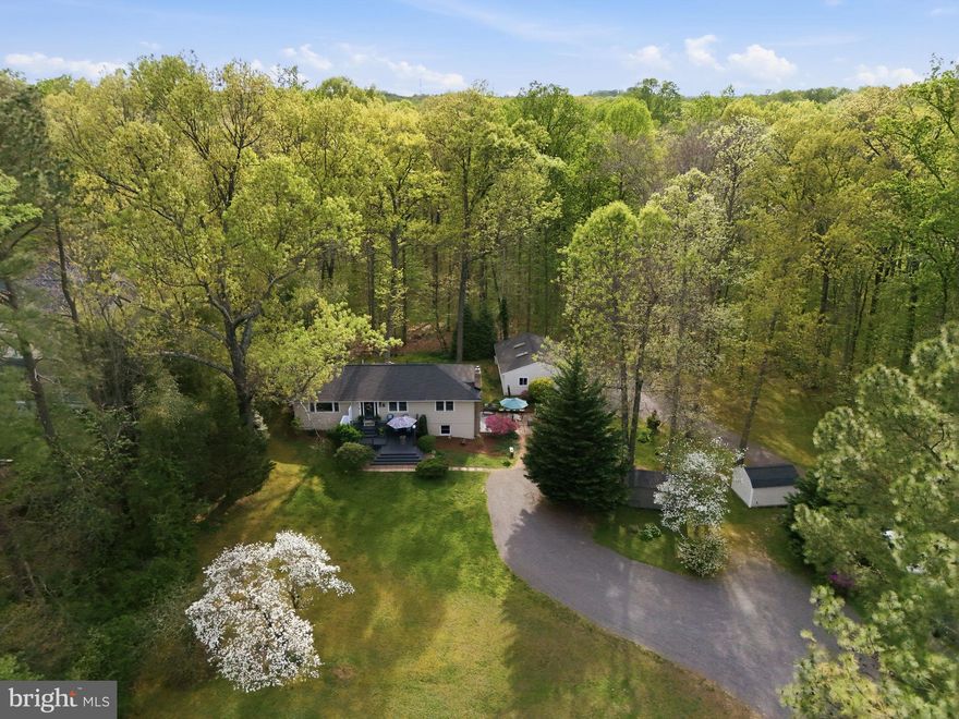 Welcome Home to 10804 Lake Jackson Dr. This home offers Main Level living of on Tranquil FIVE (5) + Secluded Acres, just 2 miles from the modern convenience of restaurants and shopping. Stately Evergreen Pine trees line the driveway offering a warm 'Welcome' while you come home after a long day at work.  As you will pull into this driveway; serenity, tranquility and peace will surround you.  Breathtaking views from every window in the house showcase park like views.  Manicured expansive front yard offers unmatched natural beauty in every season. Enjoy a morning coffee or your favorite beverage on your very own Front Deck and enjoy the breathtaking seasonal beauty.  This is a RARE OPPORTUNITY to own such a gem in Manassas.  Don't wait, this won't last!  NO HOA and A-1 ZONING offer a great potential for many life styles.
 
This home offers a 3 Car Detached  Garage,  2 Sheds with electricity.  3 bedrooms, Upgraded 2 full baths and one half bath.  A Den in the lower level serves as an additional cozy bedroom. A Large recreation room has a brick fireplace with wood pellet Stove Insert and a direct access to the lower-level Patio. A large Storage room that is ideal space for storage or convert that into your home office.  Gleaming wood floors, new roof on the main house and garage, Two (2) storage sheds with electricity - great space for an Art Studio or just extra storage. 

List of Upgrades done over last few years:
MARCH 2026: Hardwood Floors refinished. Main Level walls and Trim painted.
Custom faux wood Levolor blinds and ne window treatment.
WINTER 2024: Remodel Downstairs Den/Bedroom with new floors and new paint. New carpeting on stairs.
JANUARY 2023: Primary Bathroom update with new light fixtures, shower with subway tile, sink, toilet and flooring.
DECEMBER 2022: Downstairs Bathroom updated with new flooring, sink and a new toilet. New flooring in Laundry Room.
AUGUST 2022:  New water softener.
JUNE 2022: Hot water tank replaced.
JULY 2021:  All Structures roofing replaced with Architectural Shingles. This included the house, garage, two sheds and lean. New Gutter Guards installed on the house and a new attic fan.
JULY 2019: New Well Pump.

****No  HOA, A1 Zoning..... offer s a great potential for many life styles!