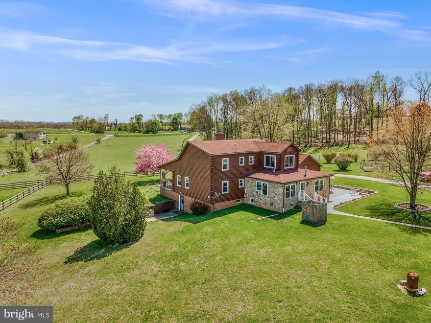 Open House this Sunday (4/26) from 11AM-1PM!! Spring has sprung at 1720 E Deep Run Rd! Incredible views, land, layout, and custom home await you on over 7 open acres and with over 3,500sf of living space at 1720 E Deep Run Rd. Find yourself, your animals, and your equipment perfectly at home in this thoughtful, completely turnkey farmette in Carroll County. The main house sits 600ft off the main road in the middle of the property, whose perimeter is entirely fenced. The custom log home features a stunning, expansive covered front porch with a front entrance to your wonderful vaulted ceiling, 2-story living room. The home has stunning hardwood flooring throughout, with some areas featuring tile or an upgraded LVP. The large but cozy eat-in kitchen features a custom stone fireplace and mantel, and direct access to the second entryway/mudroom, attached 2 car garage that features an entirely functional second kitchen (!) and formal dining room. The oversize, first floor laundry room with tile floor is off the kitchen as well. A gigantic family room addition flanks the rear of the home, with bar area, propane fireplace, pass through window to the kitchen, and access to the backyard. The first floor is completed by a bedroom with hardwood flooring and half bath. Upstairs, a stunning primary suite features a cathedral ceiling, sitting area bump out with windows on 3 sides, full upgraded bathroom, and ample closet space. An additional spacious bedroom with en suite full bath completes the second floor, which overlooks the living room via a hallway catwalk. The fully finished, heated basement has built in shelving throughout, a walk-out entrance and third full bath, with absolute potential for an in-law suite, private office space, and more. The 2015 barn is large, completely functional, and easily modified for a variety of needs, currently housing 5 large stalls in a center-aisle layout, roll up garage doors, and lots of storage. The additional Barn/Workshop has a cement floor that includes a covered pit for working on vehicles and farm equipment. It's large enough to store lawn equipment, a tractor, and can be used for hay storage. Also, there is a large room attached with lots of shelving, which can be a lounge, tack room, etc. There is electric throughout and water. Attached to this space is an additional area for hay storage, equipment, or another stall/run-in. There is also a large chicken coop with multiple access points! All of the paddocks are connected for exceptional functionality and flow, and there is space for an arena. The panoramic vista surrounding the property is breathtaking. You are just minutes from the Hanover Watershed and Hashawa Trails. This is a gem of a turnkey farmette that is move-in ready for the 2 and 4 legged members of any family. Any hobby, homesteading, homeschooling, produce, outdoors, crafting, 4-H, personal interest pursuit can easily take shape at the dynamic canvas that 1720 E Deep Run thoughtfully presents. Make this truly special property yours and watch your dreams unfold - with amazing skyscapes in the background!