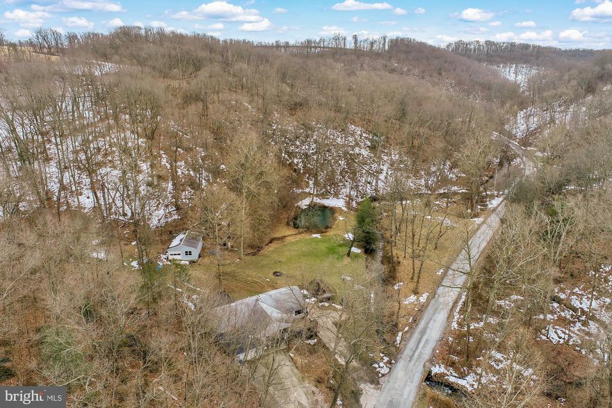 Do you want to get off the grid, but still need to be conveniently located to schools and shopping?  This is the perfect sportsman's paradise -- stocked stream runs through a large portion of the property, tons of pristine woodland for hunting, or just privacy and hiking!   The 3 BR, 2 BA raised ranch offers a large eat-in kitchen, main level laundry, large master bedroom with walk-in closet and full bath and large living room with great views of the creek and surrounding woodland.  The cozy woodstove will take the chill off on those winter nights, as well as reduce heating costs -- you have all the firewood you will ever need right on your property!  The potential also exists to sell some of the trees for timber value if you like.  Sit on your front porch swing or back patio and watch the wildlife or just absorb the peace and quiet!  There is plenty of storage for your cars or toys in the 2 car built in garage on the lower level, attached garage on the main level, as well as the great pole barn!  Showings by appointment only -- please do not stop and wander around the property without an appointment with an agent.