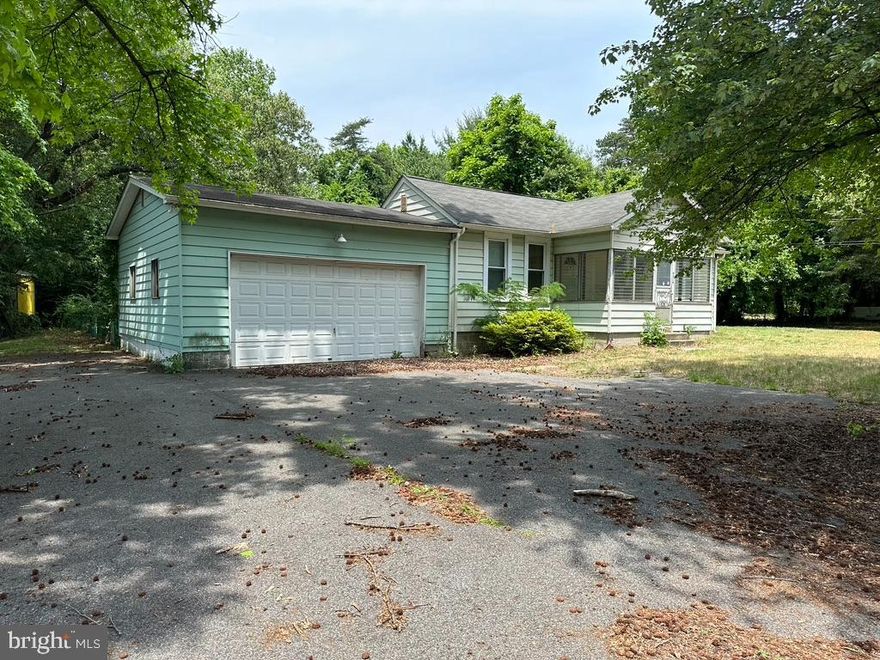 Spanning over 1000 square feet, this home Rock Creek Park home boasts three large bedrooms, offering ample space for comfortable living. Large windows throughout allow plenty of natural light to fill the rooms, creating a bright, welcoming, and cozy atmosphere.

One of the highlights of this property is its two enclosed porches. The front porch faces a peaceful heavily-wooded area, allowing you to relax and enjoy the serene natural surroundings. The additional enclosed porch at the back of the house offers a similar tranquil view, providing another space for relaxation,  taking in the scenery, and decompressing.

Situated on over 1/2 acre of land, this property provides a generous amount of outdoor space. The sizeable lot allows for various outdoor activities and offers an opportunity to create your own private retreat. Being just far enough off the beaten path, you can enjoy a peaceful atmosphere away from the hustle and bustle of daily life, and still close enough to make those late-night runs to the grocery store with no problem.

Step downstairs to the basement with massive potential.  Finishing the basement will double your living space for storage, recreation, an office, a home gym, or just about anything else you can imagine.

Plenty of off-street parking with an attached 2-car garage and a parking pad that will accommodate at least three other vehicles and no HOA, 9216 Ft. Smallwood Road is waiting for someone to turn this house into a home.