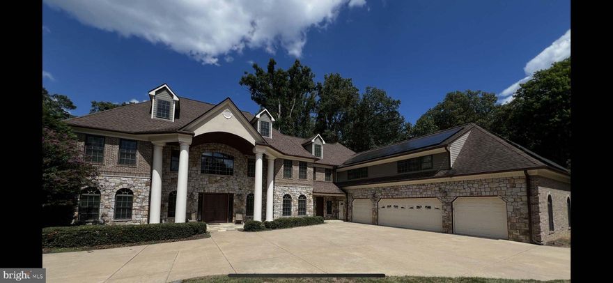 Extraordinary Private Estate on 5 Fully Fenced Acres: Experience the rare combination of luxury living, resort-style amenities, and exceptional equestrian potential in this remarkable approximately 12,000-square-foot estate set on 5 beautifully maintained, fully fenced acres. Designed for both grand entertaining and comfortable everyday living, this one-of-a-kind property offers unmatched space, versatility, and privacy. Originally designed as a horse property, the estate features a 3-stall barn with concrete floor and hayloft, riding ring, pasture area, and electric wiring throughout all 5 acres. With 8 access gates, a gated front entrance with dual remote-controlled gates, and expansive open grounds accented by groomed tree-lined areas, the property is as functional as it is stunning. The riding ring also offers exciting flexibility and may be converted into a sports court or private tennis court. The southern exposure residence itself showcases 6 bedrooms and 6 bathrooms, including 4 master bedrooms, making it ideal for multigenerational living, guests, or luxurious private suites. Inside, you’ll find an open floor plan, soaring ceilings, oversized 8-foot interior doors, wide hallways, and elegant finishes throughout, including fine trim work, recessed lighting, and cove lighting in recessed ceilings. Comfort and privacy are elevated by sound insulation between bedroom and bathroom walls, select floors, and insulated solid doors. This home is exceptionally well-equipped for modern living with two kitchens, three laundry rooms, an exercise room, game room, built-in bar with sink, plumbing, and TV near the pool, two fireplaces, and a 4-stop, 2-door elevator providing convenient access throughout the home. The luxurious primary bath features a steam shower, while two master baths include air tubs for spa-like relaxation. Step outside and enjoy a true private retreat. The grounds are enhanced by landscape lighting throughout the front and back acreage, multiple decks, an outdoor kitchen, and an outdoor shower. Relax by the in-ground heated saltwater pool and deck, complemented by wiring already in place for a future hot tub. A 1/8-acre vegetable garden with a 10-foot chain link fence and double gate adds both charm and functionality, while an array of fruit trees—apple, peach, cherry, pear, and nectarine—bring beauty and abundance to the landscape. Mature Crape myrtles line the front of the property, creating a memorable first impression. Built with long-term efficiency and resilience in mind, the estate includes an owned hybrid 28.8 kW solar system, offering the ability to sell power back while also providing off-grid capability, along with an owned generator and 1,000-gallon underground propane tank. The property is supported by 800 amp electrical service, three HVAC systems including one geothermal system, energy-efficient windows and doors, and a long list of substantial infrastructure upgrades, including new water heaters, new water filter and softener systems, new water main, new well pump, and updated septic components. The average monthly electric bill is approximately $200. Car enthusiasts and hobbyists will appreciate the oversized climate-controlled 4-car garage with drive-through access and tall, wide doors for oversized vehicles or equipment. With its 95% stone and brick exterior, complemented by hardy-board siding, this home offers enduring quality and timeless curb appeal. "Hidden Spring Farm" is more than a home—it is a private estate built for luxury, recreation, sustainability, and lifestyle flexibility. Whether you envision an equestrian retreat, entertainer’s paradise, or secluded family compound, this property with its rare functional acreage, exceptional amenities, strong school pyramid, and easy access to Reston, Tysons Corner, Springfield and Washington, D.C., presents a unique opportunity to own a truly exceptional Northern Virginia retreat.