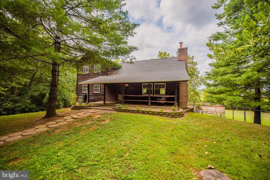 Live the West Virginia dream of a beautiful cabin in the woods with private water access!  Very stylish 3 bedroom log cabin featuring an open area living room with a French inspired kitchen and vaulted ceilings, exposed beams, and hardwood floors.  First floor master bedroom and office.  New roof installed in 2017; gutters installed in 2018.  Walkout basement features den and workshop area plus, full bath, and a custom closet for conditioned wine storage.  Large 35x30 detached garage and workshop with attic loft, stainless steel work bench, 1/2 bath and 2 car carport.  Lot also includes a 10x20 storage building, fenced play area, and outdoor dog kennel.  All set along a private 350'+ stretch of the Opequon Creek.  No active HOA.  Contact agent for property disclosures.