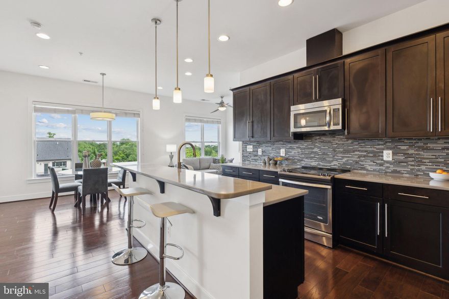 This stunning penthouse has incredible views for miles, and the scenery must be seen to be believed! You are immediately welcomed by 10-foot ceilings and expansive windows that flood the space with natural light. This very spacious unit has 1,290 square feet, making it much larger than the average 2bd Arlington condo. The kitchen is a standout feature, equipped with stainless steel appliances, granite countertops, and a large island for prep or additional eating space. 

Both bedrooms are thoughtfully positioned on either side of the condo and have their own en-suite bathrooms for maximum privacy. The master bedroom has a spacious walk-in closet, a dual vanity, and a glass-enclosed shower for a spa-like experience. The second bedroom is equally well-sized with great closet storage space and views. 

Set in a beautifully maintained, secure-access building, residents enjoy landscaped grounds and reserved parking. With a blend of thoughtful design, top-tier finishes, and everyday convenience, this home is a perfect blend of comfort and sophistication.