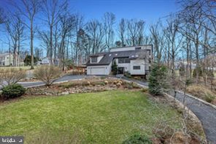 Contemporary Retreat on a Private Wooded Lot. Nestled on 3.12 acres with wooded and water views, this beautifully updated contemporary home offers the perfect blend of modern style and natural serenity. With 4 bedrooms, 3.5 bathrooms, and hardwood floors on all three levels, this move-in ready home is designed for both comfort and sophistication. The main level features walls of windows that flood the living and dining rooms with light, both warmed by a striking two-sided stone fireplace. The updated kitchen boasts an island with gas cooking, generous storage, and seamless flow into the sunny family room with scenic views.
Upstairs, the owner’s suite is a bright retreat with skylights, a private balcony, loft office space, and a spa-like bathroom with dual vanities, soaking tub, oversized glass shower, and separate water closet. The walk-out lower level impresses with a wood-burning fireplace, full-size window, wet bar, and full bath—perfect for entertaining or guest accommodations. Updates include, new recessed lighting with dimmers, dining room chandelier, ceiling fans, and a newly paved driveway. Security upgrades feature cameras with 24-hour recording, motion, door, and glass sensors. The basement has been enhanced with additional cabinetry, a small fridge, and a new partition for privacy. With its thoughtful upgrades, stunning views, and a peaceful wooded setting, this home is ready to welcome its next owner.