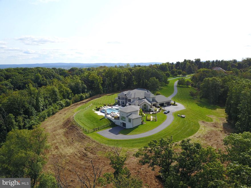Once in a lifetime opportunity to own this absolutely stunning 26.61 acre estate with over 9,000 sq. ft. of living space. Gorgeous 2-Story with 6 bedrooms, 6 ½ baths, heated, in-ground infinity pool/hot tub and pool/guest house all awaiting your arrival.  The circular driveway leads you to the double front door and into the 2 story foyer with amazing marble flooring, columns, chairrail, crown molding, motorized chandilier and a grand curved staircase to the upper level.  The formal dining room is adorned with a crystal chandeliers, tray ceiling, wainscoting and crown and beautiful hardwood.  The 2-story great room hosts a coffered ceiling, an amazing floor to ceiling stone gas fireplace with built-ins and lighting, rear staircase and a wonderful wall of windows warms the entire room.  A chef’s kitchen comes with all the appliances you will ever need, including a double wall oven, Miele instant coffee maker, Viking gas range with pot filler, Viking refrigerator, an incredible island with wine cooler and vegetable sink, coffered ceiling with recessed lighting, granite countertops, marble flooring and peninsula seating.  There is also a wet bar right around the corner with another cooler.  The breakfast area has a tray ceiling, marble flooring and two access points to the rear of the home, overlooking the pool and landscape.  The formal living room has hardwood flooring, beamed cathedral ceiling, gas fireplace with built-ins and access to the covered rear, heated patio with a fireplace, recessed lighting and tv hook up.  Luxurious first floor primary bedroom with wood floors, gas stone fireplace, crown molding and tray ceiling and a large sitting area with access to the rear patio, overlooking the pool.  The primary en suite has a soaking tub, double vanity, private storage closet and a marble surround shower with dual heads.  There is also a primary walk-in closet, with two access points, and a large center island and ample storage space.  The large, private main floor office has hardwood, crown molding, built-in cabinets and large closet, and could be used as a secondary main floor bedroom.  The main floor hall has crown molding and cabinet storage and there is a main floor laundry room with marble flooring, drying rack, sink and built-in storage, a large mud room with built-in storage/seating and a powder room.  The upper level consists of three ensuite bedrooms, all with either walk-in closets or large closets, crown molding and tray ceilings, as well as two additional bedrooms that share a jack-n-jill bath and three bedrooms have access to private balconies.  The daylight, walk-out lower level of this estate is ready to be finished off for even more living space.  The pool/guest house is absolutely amazing and comes with an open concept floor plan which allows for a great entertaining space, 2-story with bead board ceiling and lovely board and battan accent wall, a fabulous kitchen with granite countertops, range and built-in grill, wine cooler, dishwasher and indoor/outdoor seating from the pool patio, which is also heated. There is a dining area and large bedroom with 2 closets, as well as a full bath with an amazing tile surround shower.  Additional amenities included a heated 4-car garage, separate 2-car garage, whole house speaker system, including the outdoors and a security system.  Easy access to Routes 183 and 61.  You have got to see this one for yourself!