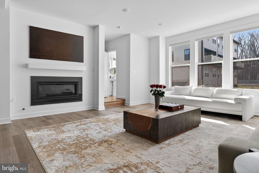 Tucked within the sought-after Boulevards at Westfields, this nearly new 2024 townhome offers a refined blend of modern design, comfort, and effortless living across three beautifully appointed levels.

Upon entry, a spacious two-car garage is complemented by a versatile lounge or recreation room—ideal as a home office, media space, or guest retreat—complete with a convenient half bath and additional storage.

A short ascent leads to the heart of the home, where an open-concept main level is bathed in natural light. The expansive living and dining areas flow seamlessly into a stunning kitchen, featuring striking black subway tile, warm-toned cabinetry, and a bright, airy ambiance that feels both contemporary and inviting. Perfectly positioned mid-row with no direct homes in front, the residence enjoys an abundance of natural sunlight throughout the day. A private deck extends the living space outdoors—ideal for entertaining or relaxed evenings of grilling.

The upper level is thoughtfully designed for both comfort and functionality, highlighted by a serene primary suite with a walk-in closet and a well-appointed en-suite bath. Two additional bedrooms, a full hall bath, and a conveniently located laundry room complete this level.

Enhancing the home’s modern appeal are smart features including an integrated speaker system and select motorized shades, both easily controlled from your phone.

Stylish, sun-filled, and exceptionally well maintained, this residence presents a rare opportunity to own a truly turnkey home in one of Chantilly’s most desirable communities.