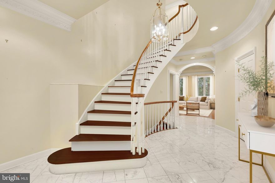 The Berkley neighborhood residences are  synonymous with quiet luxury and restrained elegance. Nestled within the newest section of  Battery Kemble Place, this distinguished enclave, on the site of the former Rockefeller Estate, is 4813 Kemble Place.  The home is a classic brick colonial blending traditional principles with modern livability. Perfectly symmetrical, the facade evokes cues from classic estates of the past. Inside, the central entry hall creates a formidable initial impression, with gleaming Carrara marble floors and a sweeping grand staircase. Detailed plasterwork throughout the main level consists of thick, carved crown moldings and archways framed by columns. Formal rooms are generously proportioned. The dining room is embassy sized, with two walls of glass and access to a private balcony for al fresco entertaining during the warmer months. A substantial living area in the rear spans the entire width of the home. Lavishly appointed yet still warm and intimate, the space features accent lighting and is anchored at one end by an intricate, roaring fireplace. A wall of double casement windows and access to a second private balcony complete the area. Upstairs, the primary suite is accessed through double doors. The large sleeping area connects to a five-piece marble bath and walk-in closet space. Secondary bedrooms are each ample in both scale and storage. The grand staircase leads to the walkout lower level in a gracious arc. Sitting above grade, the ethereal space is flooded with natural light. A large recreation room features extensive built-ins on two walls, flanking a roaring fireplace. A professional, mirrored fitness room and guest bedroom complete the space. Shaded by verdant foliage and shrouded in privacy, the rear lawn offers usable green space. Convenient to Georgetown, Downtown, and major commuter routes, 4813 Kemble Place is an exemplary residence in one of DC’s most sought-after locations.