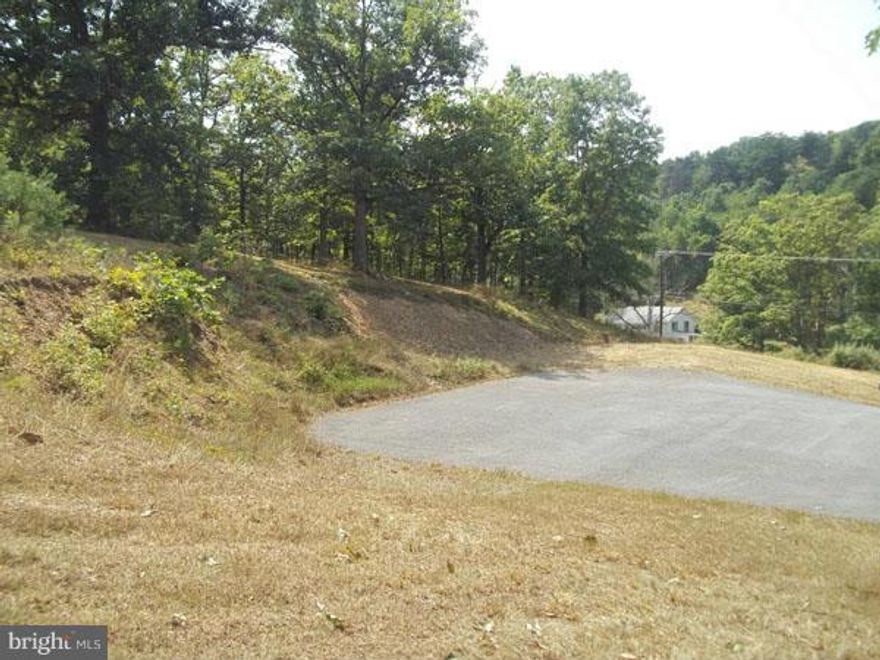 Property is located close to town of Berkeley Springs, WV, is a unrestricted 3.61 open acres with some old time growth oak trees. Well and septic have been installed and electric is one property, paved driveway with plenty of off street parking  and building site has been cleared. Most of site prep has been completed for you.
