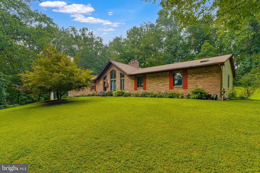 ***SELLERS ARE OFFERING $5,000 BUYER CREDIT FOR COSMETIC UPDATES ***

Tucked away in the Forest Hill neighborhood of Sharon Acres Estates, this spacious 5 bedroom, 3 ½ bath home is a private oasis surrounded by mature trees on a serene 4.3-acre lot. As you approach, you'll notice the long, paved driveway features a convenient loop and leads to abundant parking and an oversized 2-car garage.

The main level of this charming home is designed for one-level living and boasts gorgeous hardwood floors, cathedral ceilings, floor-to-ceiling windows that invite ample natural light, and rustic wood beams. A double-sided wood-burning fireplace adds coziness and warmth, complementing the open-concept floor plan. The spacious kitchen is a culinary delight, featuring abundant cabinetry, granite counters, updated stainless steel appliances, recessed lighting, and a welcoming eat-in dining area. For formal gatherings, a separate dining room awaits.

Convenience meets practicality with a main-level laundry room and powder room located off the kitchen. You'll also find sliders that lead to both a wood deck and a screened-in porch with cathedral ceilings, offering the ideal spaces for relaxation and outdoor enjoyment.

The main level further includes two large secondary bedrooms, a full hall bathroom, and a primary bedroom retreat. The primary bedroom boasts a walk-in closet and a private ensuite bath, complete with double sinks, a shower, water closet, and space for a soaking tub or larger spa shower.

The lower level of this remarkable home is fully finished and offers a private entrance, making it perfect for extended family stays, an in-law suite or rental income potential. This level features two bedrooms, one full bathroom, a generously-sized open living area, a full kitchen layout, and a huge storage area for added convenience.

For those who appreciate sustainable living, the property includes a chicken coop with electricity and a charming firepit area for outdoor gatherings. This home truly has it all – a picturesque setting, versatile living spaces, and a perfect blend of modern amenities and natural beauty. Welcome to your dream home, where wildlife abounds and tranquility awaits!

Recent updates:
Remodeled 1/2 bath 2023, Garage doors and well pump 2021, Roof 2018
Within last 3 years: Heat pump, hardwoods installed, driveway paved, Leaf Filter system