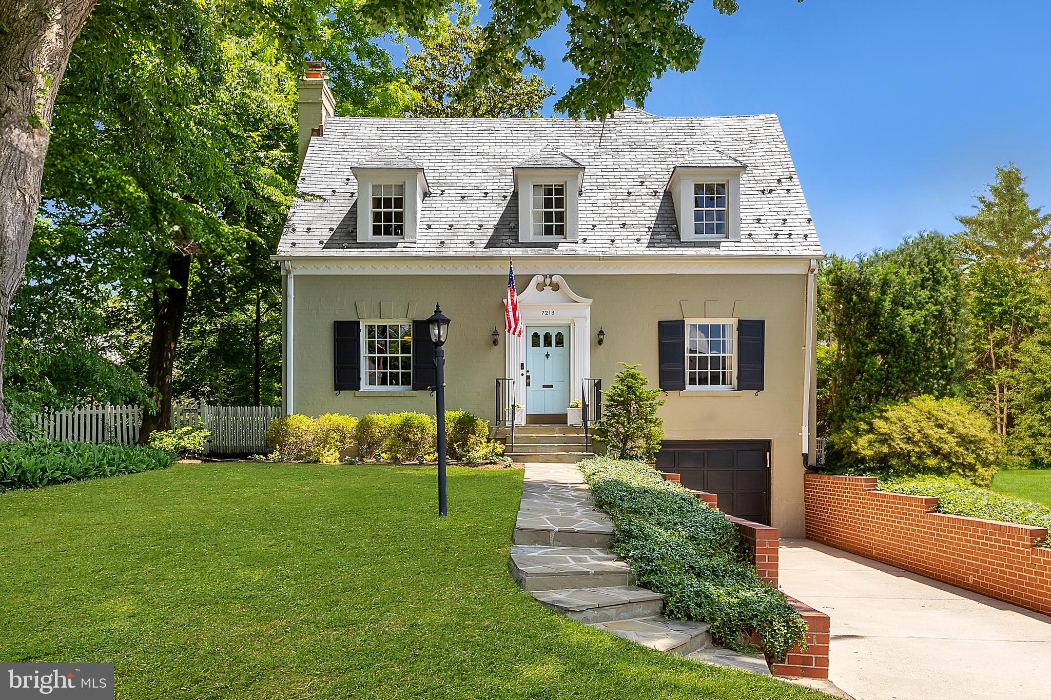 Set back from the verdant street in the heart of idyllic Martin’s Additions in Chevy Chase is this charming colonial. Originally constructed in 1935, the home retains its historic character while being fully upgraded to meet contemporary lifestyle preferences. A flagstone walkway leads to the inviting front entrance, where the home’s classic symmetry and dormers embedded in the slate roof offer effortless curb appeal. The traditional center hall floor plan features formal living and dining rooms flanking the entry foyer. Both spaces are generously proportioned, with the living room showcasing a roaring fireplace and the dining room providing an ideal setting for dinner parties. Accessed via double doors off the living room is a private study complete with new custom built-ins and views out to the garden. In contrast to the formal areas, the informal spaces are open concept, suited to a modern style of living. The chef’s kitchen is the heart of the home, featuring modern cabinetry, stone countertops, stainless steel appliances, a commercial range,a stylish hood vent,and spacious pantry. A new backsplash and lighting enhance the space, which opens to the spacious family room. Here, a cozy wood-burning fireplace, refinished built-ins that offer ample storage, a large bay window, and direct patio access create the perfect gathering place. An elegant, newly renovated full bath completes the main level. Upstairs, the luxurious primary suite features an inviting integrated bench beneath the bay window, private roaring fireplace, and new closets. Its sumptuous ensuite bath boasts a double vanity, soaking tub, and separate walk-in glass shower. Two additional bedrooms and a hall bath complete the upper level offering ample accommodation. The freshly updated lower level offers a recreation space for true multipurpose flexibility. The newly updated powder room and direct access to the attached garage complete the space. A true highlight of the home is the parcel of land it is situated on, for both its outdoor space and prestigious location. Adjacent to the flagstone patio off the family room is a large, flat, usable grassy backyard. Fully fenced and shaded by lush, mature foliage, the rear lawn offers complete privacy and is effortlessly maintained by the all encompassing irrigation system. The unparalleled location is steps away from Chevy Chase Park, the weekly farmer's market, Olympia Cafe, Brookville Supermarket, and the legendary La Ferme Restaurant, as well as falling within the CCRA Swim and Tennis Club scope. Perfectly blending historic charm and modern livability and situated in one of the Capital Region’s most sought-after communities, 7213 Chestnut Street represents the epitome of Chevy Chase living.