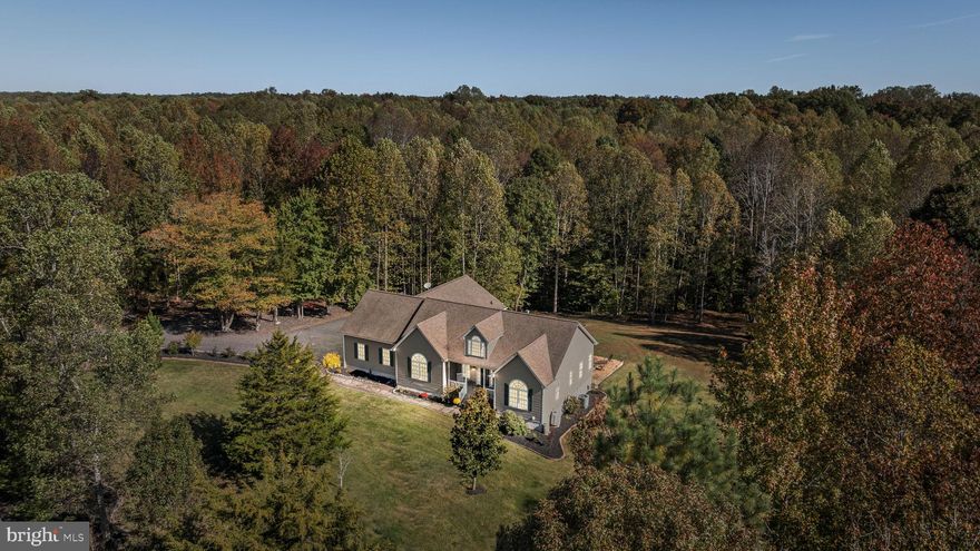 Welcome to this exceptional, move-in-ready custom home featuring 4 bedrooms and 4 full
bathrooms with over 5,000 finished sq ft, set on 10 private acres. Offering the perfect balance of
luxury, functionality, and peaceful country living, this property has been thoughtfully remodeled
with high-end finishes throughout, ideal for both everyday living and entertaining. 
The main level boasts an open gourmet kitchen anchored by a generous center island. The
quartzite countertops, hammered copper farmhouse sink, hammered copper beverage sink,
matching copper hood over the range, pot filler, custom tile backsplash, wine & coffee bar, and
abundant cabinetry are a chef’s delight. From the kitchen, the dining room flows seamlessly into
the spacious living room with soaring vaulted ceilings, gas fireplace, and rich tobacco wood
flooring. The main-level owner’s suite features new carpet, a walk-in closet and a spa-inspired
ensuite with dual vanities, luxury vinyl plank flooring, linen closet, separate shower, and soaking
tub with chandelier. There are two additional bedrooms on the main level both with oversized
closets, ceiling fans and fresh paint. The front bedroom has new carpet and high vaulted ceilings,
while the rear bedroom has hardwood flooring. Both served by a guest bath with dual marble
vanities and a generous linen closet. Upstairs, a spacious loft suite features new carpet, fresh
paint, and a private bath with LVP flooring and a freestanding shower. Located on the main floor,
the generous laundry room has multiple cabinets, counter space, and a secondary fridge for
added convenience.  Downstairs the finished, walk-out basement expands the living space with two large recreation rooms, along with a kitchenette including beverage cooler, small fridge, sink, and ample cabinets
under a custom-made L-shaped bar top. Additional spaces include a full bathroom, a sound-
proofed theater room option, and a spacious unfinished storage room. The pool table, cue rack,
billiard light, bar stools, and some gym equipment will convey. The basement could also serve as
rental space with its own private entrance. Additionally, the oversized two-car garage has ample
woodshop space, built in cabinets, rolling worktable, durable high-end epoxy-sealed floors, 12-
foot ceilings, paneled walls, and a built-out storage loft above the parking area. 
Outdoors enjoy the morning sun while watching deer wander by from the covered back deck, or
on the covered front porch while smelling your rose blooms. Additionally, the backyard has a fire
pit on a large pea-gravel pad perfect for BBQs and parties while a fenced garden or chicken coop
area flanked by flowering wisteria bushes offers space for a quiet side hobby. Much of this
beautiful property is wooded, while still offering plenty of lawn to enjoy and is accented in front
with white vinyl estate-style fencing. The long driveway provides plenty of parking and includes
a bonus canvas covered lawn equipment storage shed, which sits camouflaged off to the side.
This one-of-a-kind property offers everything you could want — space, style, and privacy — all
within a short drive to Fredericksburg and Dahlgren Naval Base.