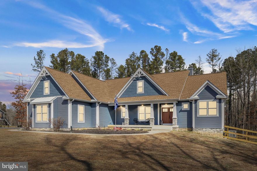 A stunning Craftsman-style home built in 2019 by Spartan Homes — loaded with upgrades and perfectly positioned as your Lake Anna water-access retreat. This 5-bedroom, 4-bath home (plus bonus room and private office) sits on a sprawling 5-acre cul-de-sac lot in The Waters at Lake Anna, one of the most desirable communities on the private side of Lake Anna. Life here feels like a resort. Enjoy an in-ground pool, sandy beach, clubhouse, boat ramp, tennis, pickleball, basketball, playground, and more. The community offers 9 day slips plus 11 boat slips available for annual lease. High-speed fiber internet is available, so working or playing from home is seamless. Inside, you’ll find over 4,400 finished square feet with an open-concept main level featuring 9-foot coffered ceilings, durable LVP flooring, and a striking stone wood-burning fireplace. The kitchen was designed for gathering — complete with double wall ovens, a 5-burner gas cooktop, oversized island with seating, granite countertops, black stainless steel appliances, a copper sink, tiled backsplash, and a walk-in pantry. The main-level primary suite features his-and-her walk-in closets, separate vanities, and a tiled walk-in shower with dual shower heads. Two additional bedrooms, two full baths, a home office, and laundry room are also conveniently located on the main level. Upstairs, the massive bonus room with a mini-split system is perfect for a game room, bedroom or additional guest space. The finished walkout basement adds even more room to spread out — featuring a large family room, rec area, gorgeous bar, two bedrooms, a full bath, and plenty of storage. Outdoor living shines just as much as the interior. Relax on the screened-in porch with vaulted ceilings and a stone wood-burning fireplace, enjoy the composite covered deck, and let kids or pets play safely in the fenced backyard. Additional highlights include an oversized finished 3-car garage, paved driveway, whole-house Generac generator, and tankless water heater. All of this in a golf cart–friendly community just minutes from groceries, dining, coffee shops, and local favorites like Lake Anna Taphouse and The Yacht Club. This one truly checks all the boxes.
