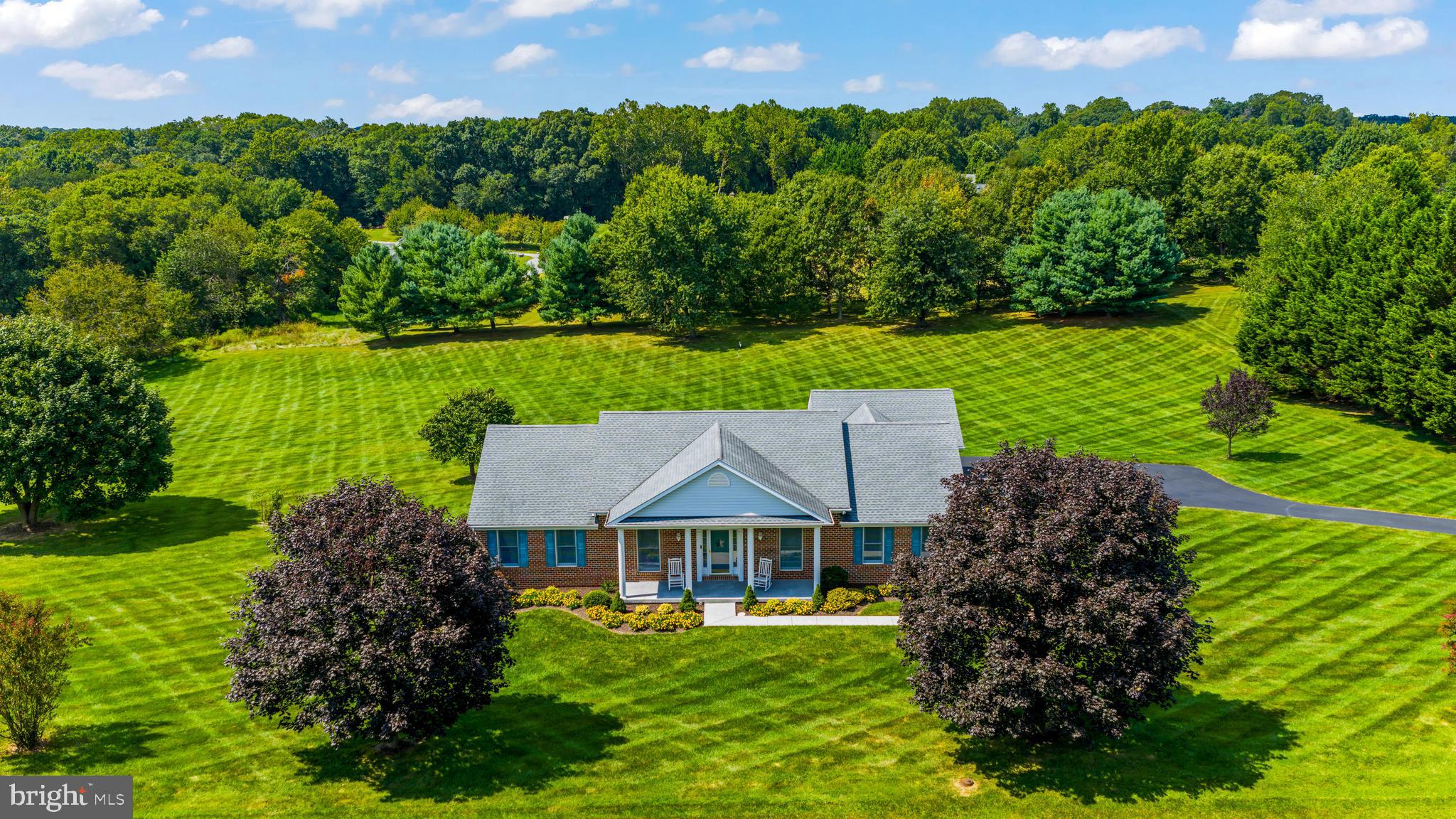 Welcome to 630 Johnsville Road. This is the house you drive past all the time, curious what life would look like living in such a special property. Now is your rare opportunity to explore the lifestyle for yourself.
Nestled on a manicured 3 acre property in the heart of Eldersburg, this residence offers privacy, elegance, and effortless living. The stately curb appeal and meticulously landscaped grounds set the tone for what awaits inside.
Step through the generous entry and discover a light-filled interior designed for both intimate gatherings and large-scale entertaining in an open floor plan.
The chef’s kitchen is open to the living and dining areas and opens to the maintenance free back deck. Enjoy professional-grade appliances, custom cabinetry, and a seamless flow into the dining and living spaces. Expansive windows frame sweeping views of the property, while soaring ceilings and refined finishes create an ambiance of understated luxury.
This is main level living at its prime. The primary suite is a retreat unto itself, complete with a spa-inspired bath and spacious walk-in closet. Two additional bedrooms offer comfort and style, while versatile living spaces provide room for work, play, and relaxation. The lower level is open with tall ceilings, an egress door and egress windows. Finish this space for additional options for life or entertaining or keep it open for your storage needs. The possibilities are endless in this blank space.
Outdoors, the property shines with multiple entertaining areas, A putting green, lush lawns, and endless possibilities for creating your own private oasis.
Impeccably maintained and thoughtfully appointed, 630 Johnsville Road is more than a home—it’s a lifestyle.