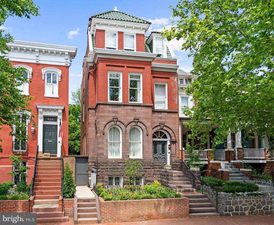 Built in the late 19th century and set along one of Georgetown’s most picturesque tree-lined streets, this impeccably reimagined residence, a striking example of Romanesque Revival architecture, characterized by heavy masonry, rounded stone arches, and a richly textured façade, represents a rare convergence of historic Washington architecture and world-class design. Thoughtfully transformed by the acclaimed teams at Zoe Feldman Design and BarnesVanze Architects, the home has been meticulously curated to achieve a level of craftsmanship and refinement seldom found in the city’s residential market.
Behind its stately Georgetown façade, soaring ceilings, grand proportions, and beautifully restored architectural details are paired seamlessly with richly layered contemporary interiors. A generous foyer welcomes guests into the home, anchored by custom built-in cabinetry and a gracious stair hall that immediately establishes the home’s sense of scale and sophistication. The main level unfolds beautifully for both everyday living and formal entertaining, offering an elegant living room and an adjacent dining room with dramatic detailing and refined finishes.
Toward the rear of the residence, the home transitions into a spectacular gathering space centered around a luxurious chef’s kitchen. Sculptural marble surfaces, custom millwork, warm brass accents, and exceptional storage define the space, while a wet bar, dedicated coffee bar, and sunlit breakfast area create an atmosphere that is both elevated and inviting. French doors open seamlessly to the expansive rear garden, offering effortless indoor-outdoor living. A discreet powder room completes the main level.
The second floor is anchored by a serene primary suite positioned at the front of the home, where oversized windows flood the space with natural light. Two custom walk-in closets provide exceptional storage, while the luxurious primary bath evokes the feel of a private spa, complete with dual vanities, a soaking tub, private water closet, and exquisite marble detailing. Also on this level is a handsome office or secondary bedroom with access to a full hall bath, as well as an inviting family room designed for more relaxed daily living.
The third floor continues the home’s thoughtful layout with two additional generously proportioned bedrooms, including one with an ensuite bath and another served by an elegant hall bathroom.
On the lower level, unusually tall ceilings create a bright and comfortable extension of the home’s living spaces. Designed with flexibility in mind, the level includes recreation and music rooms, laundry, a powder room, and an additional bedroom suite ideally suited for guests, extended stays, or a live-in au pair.
At the rear of the property, a substantial private garden unfolds as a rare urban sanctuary in the heart of Georgetown—offering beautifully landscaped outdoor living and entertaining spaces that feel both tranquil and secluded. The result is a home of exceptional scale, warmth, and sophistication: a truly turnkey Georgetown residence where historic character and contemporary luxury exist in perfect harmony.