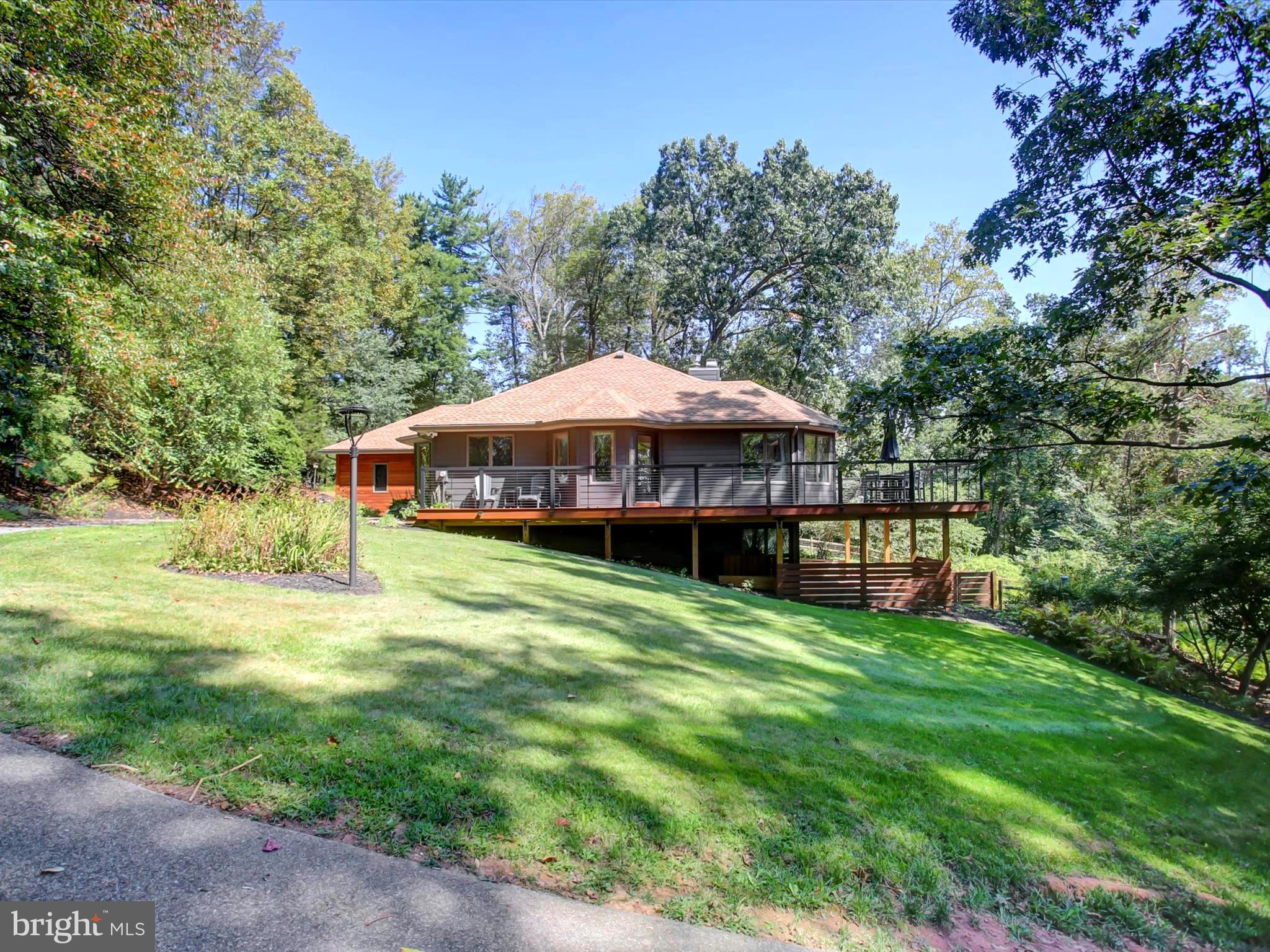 Stunning Contemporary Retreat with Panoramic Views in Dover Township. Perched atop a serene hillside in York County, this like-new contemporary residence offers breathtaking panoramic views and unmatched privacy on 5 wooded acres teeming with nature. Watch deer and wildlife roam freely while enjoying your morning coffee on the exquisite Brazilian Cherry wrap-around deck, perfect for entertaining or quiet reflection. Step inside to discover a beautifully upgraded interior featuring an open-concept design, vaulted ceilings, exposed beams, and a wood-burning fireplace in the main living area. The spacious dining area accommodates a large dining table, ideal for gatherings, while the kitchen boasts custom solid cherry cabinetry, two pantries, a wall oven, and modern dish drawers. This 3-bedroom, 2.5-bath home has been freshly painted throughout and includes tastefully renovated & upgraded bathrooms. The entire upper level is dedicated to the luxurious Primary Suite, complete with a spa-like bathroom featuring a jetted tub, walk-in tiled shower, and solid surface countertops. Additional highlights include: Rich new siding, all new Andersen windows & patio slider doors, stunning hardwood floors, and several butcher block countertops. There is an oversized 2-car attached garage with a central vacuum system for cleaning vehicles and pull-down attic storage above. The lower level is a walk-out with a gas fireplace, perfect for a recreation room or guest accommodations. Outside, you will find a fenced area for pets and a peaceful back patio. This exceptional property offers the perfect blend of modern comfort and natural beauty. Located in Dover Township, it’s a rare opportunity to own a private wooded haven with all the upgrades already done. Just a short drive to Gifford Pinchot State Park to enjoy activities such as hiking, fishing, kayaking, and swimming. In the winter, hit the slopes at nearby Roundtop Mountain Resort.