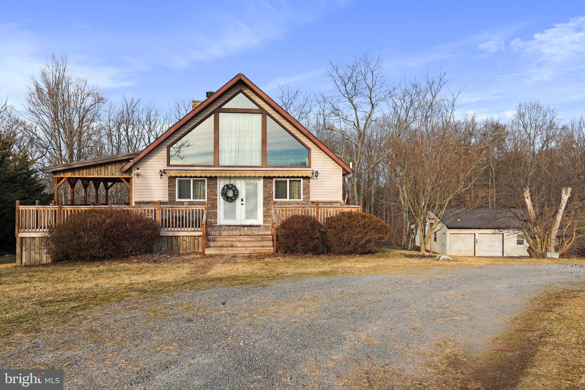 Live where you play! Play where you live! This cabin- like home offers the best of modern convenience mixed with rustic WV charm! 3 bedrooms and 2.5 baths (2 bedrooms and 1 full bath on the main level!) The main level boasts a floor to ceiling stone hearth and wood burning fireplace. The kitchen is updated with Corian countertops, a 6 burner chef's delight gas stove, new butcher block peninsula and SS appliances! The upper level has a book nook/ reading loft and another full bedroom w/ 1/2 bath. The lower level is surely crafted to entertain; complete with a game room, wood stove, secret hideout under the stairs, full bath, and possible kitchenette (or mudroom) w/ wet bar that leads to a screened in porch and hot tub hideaway! While outside, you'll be invited to roast s'mores around the fire-pit, play a game of horseshoes, or explore the +/- wooded 2 acres! Enjoy a cocktail and star gazing on the partially covered and semi- wrap around front to side porch! This home has been carefully updated to include a new radon remediation system, water softener, water filtration system, hot water heater, thermostat and washing machine! The upper level "A-Frame" windows have been tinted using a 25% commercial grade tint and some flooring has been replaced. The septic was also pumped/ checked July of 2024 and the chimney swept April 2023! Whether it be tinkering around on antique vehicles, woodworking, collecting motorcycles, or setting it up for a home gym, the detached garage will not disappoint! There is also a separate garden shed and space for lawn equipment!