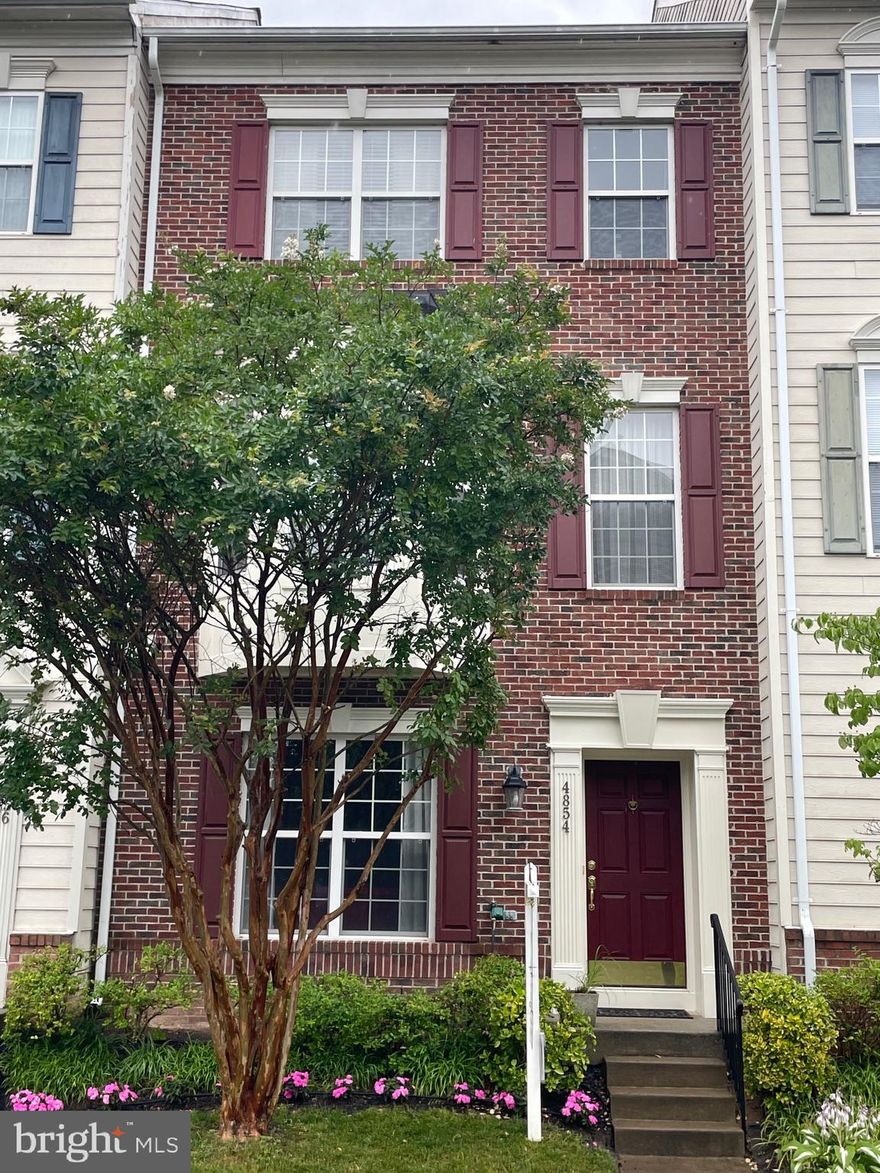 Welcome to your dream townhome! Prepare to be amazed by this charming brick-front residence, boasting lovely landscaping and a small, front green space, all your own. Upon entry, you'll be greeted by a grand foyer adorned with gleaming hardwood floors, inviting you to explore further. The lower, entry-level boasts the 4th bedroom (or office, library, den space!) plus a 3rd full bath and exit to the garage, providing you the convenience parking for 2 vehicles under roof, and additional storage!

As you go up to the main level, you'll find a space that creates a warm and welcoming ambiance for everyday meals with family and friends or entertaining a larger party! The hardwood floors flow seamlessly into a large dining room and gorgeous, light-filled kitchen with upgraded, granite countertops, black appliances, a separate pantry, an island, and an oversized eat-in space. The generous living room is perfect for quiet relaxing after a long day but also large enough to entertain a full house! The deck is just the right size for grilling your summer favorites, starting your day with a cup of coffee or tea or ending your day with your favorite cocktail!

As you continue up the stairs to the bedroom level, you will find the powder room, tucked away in the perfect spot. The upper level has 3 generously sized bedrooms that provide an abundance of living space for you and your loved ones. The master suite is a private oasis that beckons you to unwind and relax. Within its walls, you'll find soaring ceilings and plush carpeting underfoot, creating a cozy atmosphere for restful nights. The fabulous walk-in closet, offers ample storage space for all your fashion treasures. The oversized en-suite bath has a dual vanity, jetted bathtub, and separate shower. 

Just outside the owner's suite, you'll find the super convenient, bedroom-level laundry area followed by the 2nd full bath and bedrooms 2 & 3, which are pleasingly spacious!

The neighborhood offers fantastic amenities including an outdoor community pool, gym, tennis courts, trails, large green spaces, play ground, amphitheater and more! Simple access to major commuter routes makes the location ideal. 

This remarkable townhouse offers a luxurious lifestyle beyond compare. With its brick-front facade, hardwood floors, granite countertops, walk-in closets, and spacious rooms, it creates an atmosphere of opulence and comfort that will make you fall in love at first sight. Come and experience the epitome of comfort and convenience in this incredible space! Welcome Home!