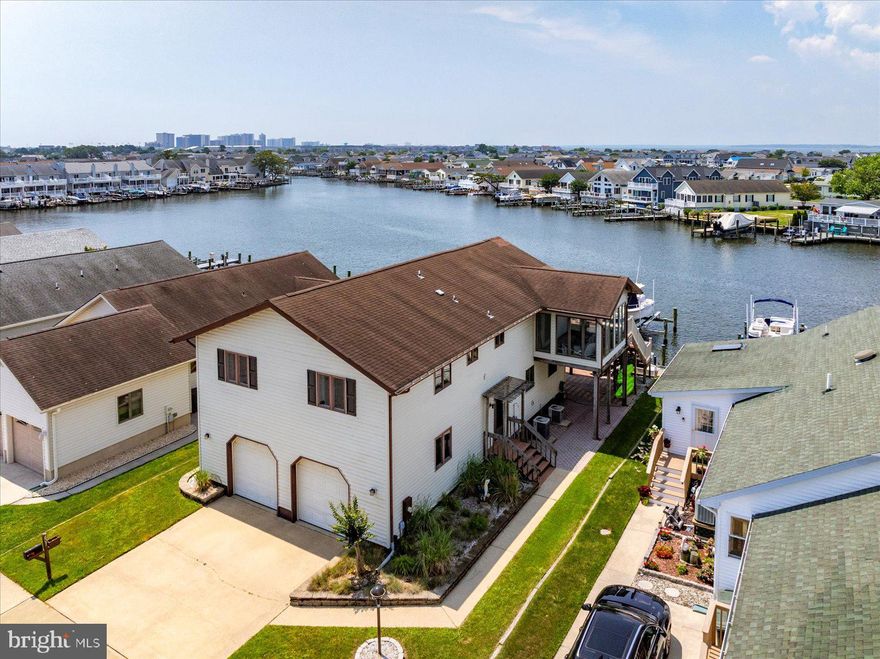 Welcome to your dream coastal retreat! This spacious 4–5-bedroom waterfront home is perfectly situated on a wide canal with expansive bay views in the highly desirable Caine Woods neighborhood of North Ocean City. With two boat lifts, a jet ski lift, and quick access to open water, this property is a boater’s paradise.  Inside, you'll find a thoughtfully designed layout ideal for entertaining and relaxed coastal living. The main level features a bright and open family room that flows seamlessly into the waterfront dining area and a large gourmet kitchen with granite countertops and ample cabinetry. Enjoy your morning coffee or evening sunsets from the sunroom or step outside to the large deck—perfect for grilling, crab feasts, and enjoying cool sea breezes.  Also on the main floor is the primary suite with en suite bath. Two additional bedrooms and a full bath complete this floor. The lower level includes another bedroom, a full bath with updated shower, a home office (or potential 5th bedroom), and a second spacious family room/game room—ideal for guests or multi-generational living.  Additional highlights include a large two-car garage with workshop area, plenty of storage throughout, and a shady paver patio for relaxing afternoons. Whether you're hosting family and friends or soaking in the peaceful water views, this home offers the best of coastal living.  Don't miss this rare opportunity—schedule your private tour today before it's gone!