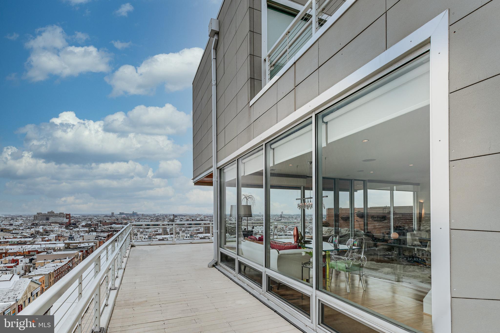 Villa 2, a corner penthouse with infinity views (east and south) offers an ever-changing urban landscape. From the great room, these unobstructed views are accentuated by the cornered glass walls that stretch seamlessly along the perimeter of the home. The abundance of natural light transforms your home into a seasonal escape. With almost 1,400 total square feet of terrace, you will be beckoned to design your own outdoor paradise. The villa's open floor plan, with its gracious living and dining areas, will grace any living and/or entertaining styles. The newly renovated jewel-box kitchen is outfitted with Italian cabinetry by Aster Cucine, Dekton countertops, Wolfe 6-burner cooktop, Thermador refrigerator, pantry and custom Miele coffee/espresso station and custom, temperature controlled, wine closet. The center island provides for eat-in seating or take advantage of an informal outdoor dining space just a step away. This pet-friendly home profiles as a 3-bedroom, 3.5 bath, 1-car (oversized) garage parking (with the potential for a 2nd car,) electric car friendly, and storage locker. The stylish living is complemented with a 24-hour doorman, social room with kitchen, extensive gym facility and secure bike room. The Lofts at Bella Vista are centrally located to all mass transit, major highway systems and within walking distance to Philadelphia's generous palette of culture, restaurants and commerce.