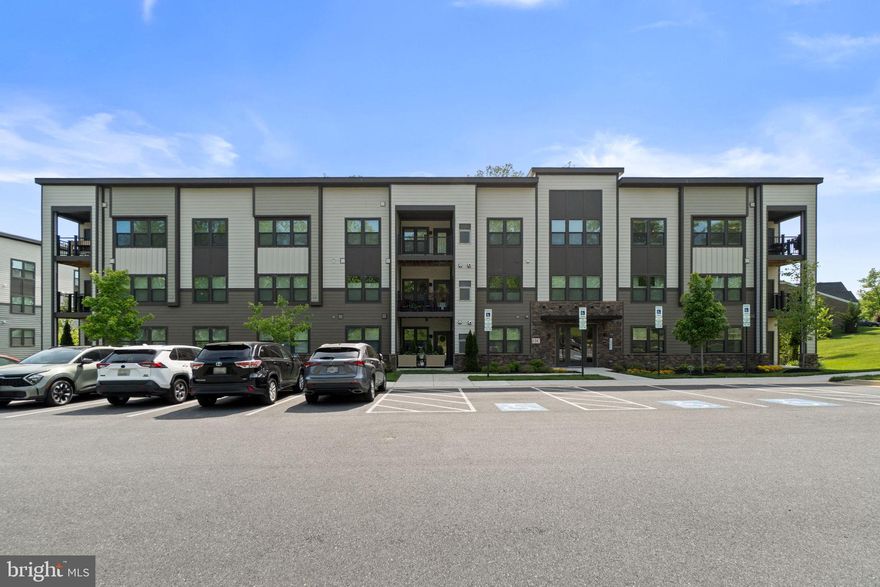 Contemporary condominium residence, newly built in 2022 by Ryan Homes, with 2 bedrooms, 2 bathrooms, and 1,554 finished square feet in desirable Turf Valley. // Step inside the freshly painted, single-level unit where gleaming floors flow from the foyer into an open-concept great room, featuring a sunlit and spacious living area with custom window shutters, direct balcony access, and an adjacent dining space. // Seamlessly connected for everyday living and entertaining, the eat-in kitchen showcases a large island with breakfast bar seating, pendant lighting, rich shaker-style cabinetry, a custom tile backsplash, newly added stainless steel appliances, and a pantry. // Just off the kitchen is a flexible bedroom or ideal home office, along with a convenient nearby laundry closet and a full bathroom. // Two additional carpeted bedrooms provide comfort and functionality, including the spacious primary suite with two walk-in closets and a private ensuite bath featuring dual vanities and a glass-enclosed shower with a built-in bench. // Enjoy tree-lined views and fresh air from the covered balcony, which offers both front and side views due to its desirable corner location. // Additional highlights include ample parking for convenience and a prime location near Turf Valley Golf Club and Golf Course, as well as nearby dining, shopping, and everyday amenities.