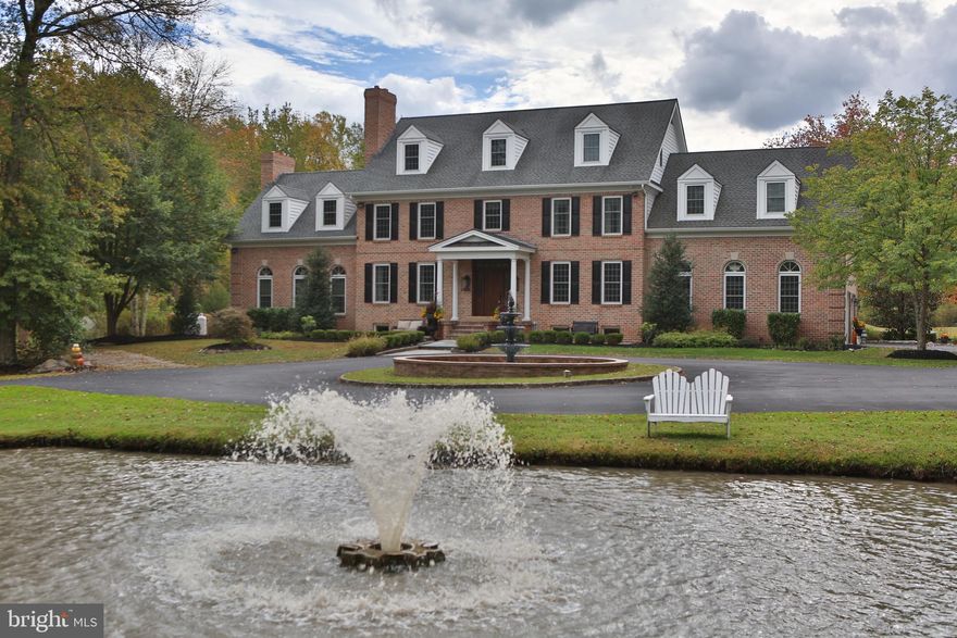 Welcome to this breathtaking 4-bedroom estate nestled in the prestigious Quail Call community of Doylestown on 10 private acres. As you arrive, a long, stately driveway lined with mature landscaping leads to a full circle drive accented by elegant fountains—setting the tone for the sophistication that awaits inside. Step into the grand entryway, where a spacious and inviting layout flows seamlessly into the formal dining room and living room. The gourmet, eat-in kitchen features stainless steel appliances, quartz countertops, a large island, walk-in pantry, and bright dining area that opens to the family room. Here you’ll find soaring 12’ ceilings, a floor-to-ceiling stone propane fireplace, striking decorative windows, and two sets of French doors leading to the resort-style pool and patio area. This level also includes a stylish powder room, laundry room with ample storage and a convenient dog shower, and access to the two-car garage. Upstairs, the luxurious primary suite offers a spacious sitting room, two walk-in closets, and a stunning spa-like bath with heated floors, heated towel racks, jacuzzi tub, dual vanities, and a walk-in shower. Enjoy morning coffee or evening sunsets from your private balcony. The second bedroom also features a modern en-suite bath and its own balcony overlooking the backyard. A third bedroom, hall bath with dual vanities, and a large guest suite with a bonus room complete the second floor. Continue to the upper level to find your private wellness retreat—complete with a fully equipped home gym (all equipment included), hot tub, sauna, and steam shower. The finished lower level is designed for entertainment and fun, featuring a media room, powder room, full bar with granite countertops, sink, refrigerator, and wine cooler. A pool table, shuffleboard, and ping pong table are all included. There is also garage access from this level for added convenience. Outdoor living is equally impressive, offering a large hardscaped patio with a built-in grill and ice maker—perfect for entertaining guests. Enjoy the sparkling in-ground pool , surrounded by picturesque views of the expansive property. Additional features include three HVAC systems for year-round comfort and a two-car garage. Located just minutes from the vibrant cultural district of Doylestown Borough—with its renowned restaurants, shops, museums, movie theater, and Doylestown Country Club—this extraordinary property offers an unmatched combination of luxury, comfort, and convenience.