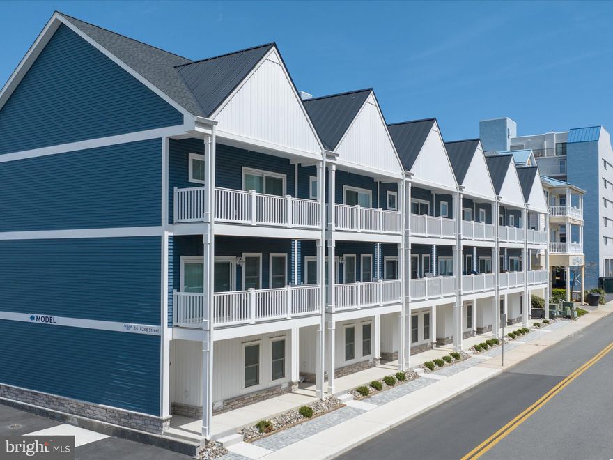 Just steps from the sand and surf, this gorgeous 4-bedroom, 3-bath end-unit oceanside townhome offers sophisticated coastal living in a prime midtown location—an exceptional opportunity to own a tastefully appointed retreat by the beach. Every detail of this home has been carefully curated, with comfortable yet stylish furnishings that elevate the interior with a welcoming, upscale coastal vibe.

The staircase, a design feature in itself, showcases painted risers, white square balusters, and a warm white oak handrail, leading you to the upper level. The main level welcomes you with an open and airy living space featuring LVP flooring throughout, recessed lighting, and silhouette blinds on every window. The spacious living room is filled with natural light and opens to a private balcony with ocean views—perfect for morning coffee or winding down to the sound of waves. Flowing seamlessly from the living area, the dining space connects to a gourmet kitchen outfitted with quartz countertops, soft-close white shaker cabinets with trim, a striking coastal backsplash, pull-out drawers, and an undermount sink. A Whirlpool smudge-proof stainless steel appliance suite completes the look, blending form and function with ease. A comfortable guest bedroom and full bath on this level add flexibility for hosting family and friends.

Travel upstairs where three generously sized bedrooms await—each with custom built-in closets. The serene primary suite offers a private balcony, a spacious customized walk-in closet, and a spa-inspired ensuite bath featuring a quartz vanity, soft-close cabinetry, and a frameless walk-in shower with a dual shower head system, niche, and a bench seat. Two additional bedrooms share a beautifully appointed hall bath with a tub and tile surround.

All the windows are outfitted with timeless Silhouette blinds, while both sliding glass doors feature remote-controlled privacy blinds—combining style and functionality throughout the home. Interior shaker panel doors and a soothing coastal blue color palette contribute to a serene, refined atmosphere. For added peace of mind, a Ring home security system is also included.

At the rear of the home, the oversized 3-car finished garage delivers unexpected bonus space. One bay has been transformed into a stylish lounge complete with LVP flooring and a flat-screen TV—ideal for relaxing after a day at the beach. The main garage bays feature an impressive slat wall system to organize all your beach essentials and durable diamond tread flooring for a polished, clean look.

Sold  furnished with minor exclusions, this exceptional property combines the effortless comfort of a beach retreat with elevated design, just a short stroll from the ocean and minutes from shopping, dining, attractions, and vibrant nightlife. Whether you're searching for a luxurious coastal getaway or a premier investment, this townhome is truly a rare find!  Schedule your viewing appointment today!