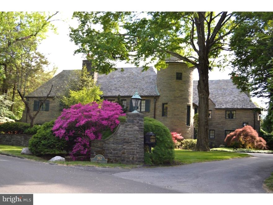The Main Line has a lot of great houses, but there are very few where the grounds measure up to the house or where the house measures up to the grounds. 262 Indian Creek Road is one of those; it is the unique and perfect blend of irreproducible and phenomenal outdoor and indoor living spaces. This elegant French Normandy country manor house was designed and built in 1927 by renown architect Paul Monaghan (the designer of the nearby St. Charles Seminary and Sacred Heart Convent) as his personal residence and has been restored, modernized and meticulously maintained by the current owners. Grand yet intimate, perfect for large-scale entertaining or for small gathering. The residence is built with 22" thick stonewalls enhanced by hand carved features and a slate roof. World famous ironwork artist Samuel Yellin created the exterior sconces, several interior fixtures, stairway bannisters and exterior railings. This charming 6 bedroom 6.5 bath French Country style manor home sits on 1.43 acres of beautifully landscaped grounds with expansive stone walls and flagstone walkways which backs up to over 20 acres of deed-restricted woods. Signature features of the home are the turret housing a hand-carved limestone circular staircase, which spans all three floors and limestone trim featured in the front foyer and living room; the very large Living Room that offers a breathtaking hand-painted coffered ceiling with exposed wood beams and a bay window featuring stained glass panels which Monaghan brought back from Europe during his travels; many dating back to the 1500's; and the fabulous grounds that were re-landscaped similarly to what they were originally.