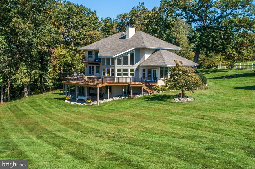 LOCATION! LOCATION! This simply stunning Contemporary home is just what you have been waiting for! Exceptionally maintained and updated inside and out! This house is set privately off the road and surrounded by preserved land, affording scenic vistas, peace, and ample natural light. The interior is designed with an open floor plan creating a spacious and airy atmosphere for day-to-day lifestyles as well as entertaining. The welcoming entrance leads you to an open living room with soaring ceilings and windows completely flooding the rooms with natural light. This home, situated in the middle of scenic country views and amidst multi-million dollar homes, is a welcomed retreat for those looking for an impressive house in a magnificent setting. Here you will find a stylish and bright eat-in kitchen with neutral granite counter tops, cook top, wall ovens and plenty of storage. Access to the very large wrap around deck is further enhanced with multiple long distance views of rolling fields and pasture. Upstairs, the main en-suite bedroom features a balcony deck for morning tranquility or sunset evenings of watching the neighboring horses. The large spa bath has a Jacuzzi tub, walk-in shower, and the convenience of a huge walk-in closet. Two more bedrooms and another full bath complete the upper floor.  Additionally, there are two more bedrooms, each with adjacent full baths, on both the main and lower level.  Each one has the potential to make a great home office, guest room, or den. There is a newly re-finished laundry room with access to an over sized three car garage with additional side entrance for lots of easy storage. The expansive walk-out lower level of the home was just recently refinished top to bottom, which includes a spacious bedroom, a bright full bathroom, and a convenient kitchenette. This versatile level, having ample natural light, offers additional private living space for family or extended stay guests as well as the flexibility to customize to your own needs. The property boasts plenty of outdoor living space with new landscaping, fencing, stone walls and of course, those panoramic views and privacy! With endless views, surrounded by Preserved Land and nobody in sight, this gorgeous setting strikes a perfect balance between contemporary living and natural beauty, providing a harmonious environment for both indoor and outdoor activities. Situated in the middle of scenic private country views, yet near New Hope, Newtown, and Peddlers’ Village makes for an easy fun retreat, second home, or downsize for those looking for a magnificent setting.  Privacy, views, low taxes and the proximity to all this area has to offer is not to be taken for granted!  Recent updates include; New roof, New HVAC, New deck, New driveway, and renovated basement which makes a perfect in-law suite with Bedroom full bath Living r room, &kitchenette.