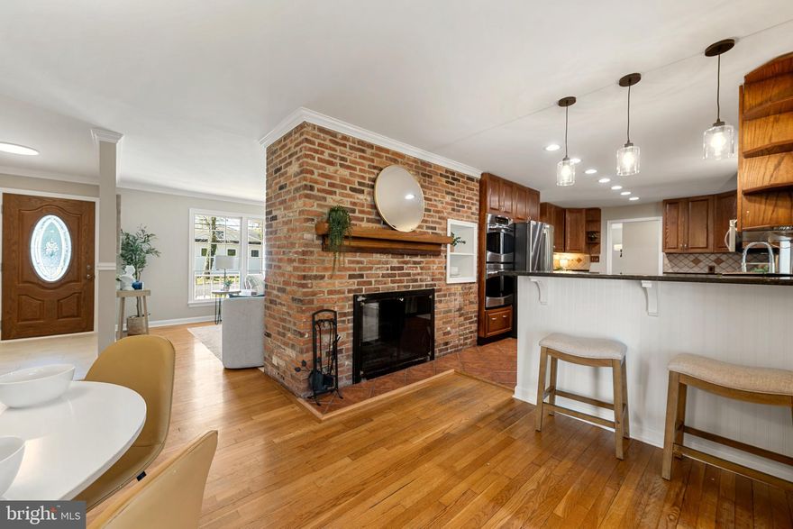 Welcome home to Southdown Shores! This beautifully maintained ranch-style home offers the ease of main level living with an inviting covered front porch, mature trees, and an oversized paved driveway with an attached 2-car garage. Step inside to find hardwood floors, crown molding, and freshly painted main living areas (2026) that set a warm and welcoming tone throughout. The sun-drenched living room is anchored by a stunning floor-to-ceiling brick fireplace with a wood mantle - oversized windows flood the space with natural light and new carpet (2026) adds a fresh, cozy feel. The layout flows effortlessly into the formal dining room featuring hardwood floors, beadboard wainscoting, and a modern pendant fixture. The expansive gourmet kitchen impresses with rich wood cabinetry with glass-front uppers, granite countertops, a decorative tile backsplash, double wall ovens, stainless steel appliances including a refrigerator and stove (2022), and a peninsula with breakfast bar seating - a wet bar and butler's area with additional cabinetry and tile flooring connects seamlessly to the generously sized family room, which opens through French doors to the rear deck. One of this home's most exceptional features is its two primary suites - both on the main level - making it ideal for multigenerational living, extended guests, or simply enjoying the privacy and flexibility of dual primary retreats. The first primary suite features new carpet (2026), a spacious walk-in closet, and a completely renovated en-suite bath with tile flooring, electric heated floors, a Bluetooth exhaust fan, and a heated towel rack. The second primary suite offers its own private en-suite bath with tile flooring and a Bluetooth ceiling fan. Additional bedrooms feature hardwood floors or carpet and generous natural light - perfect for kids, guests, or a home office. The massive unfinished lower level with interior garage access provides exceptional storage, workshop, and hobby potential. Outside, enjoy the freshly resurfaced deck (2026) overlooking the fully fenced, level backyard - a storage shed and pergola add charm and function, and a unique outdoor wood furnace supplies supplemental heat to the primary bedroom and bathroom. A new furnace (2025) rounds out the major updates. Southdown Shores community amenities include access to a sandy beach, boat launch, pier, and a community pool available for summer use. Just minutes to Beverly Triton Nature Park, The Market at South River Colony, Black Market Bakers, Weis Markets, West Marine, and local dining. Zoned for the highly regarded South River school pyramid. Schedule your showing today!