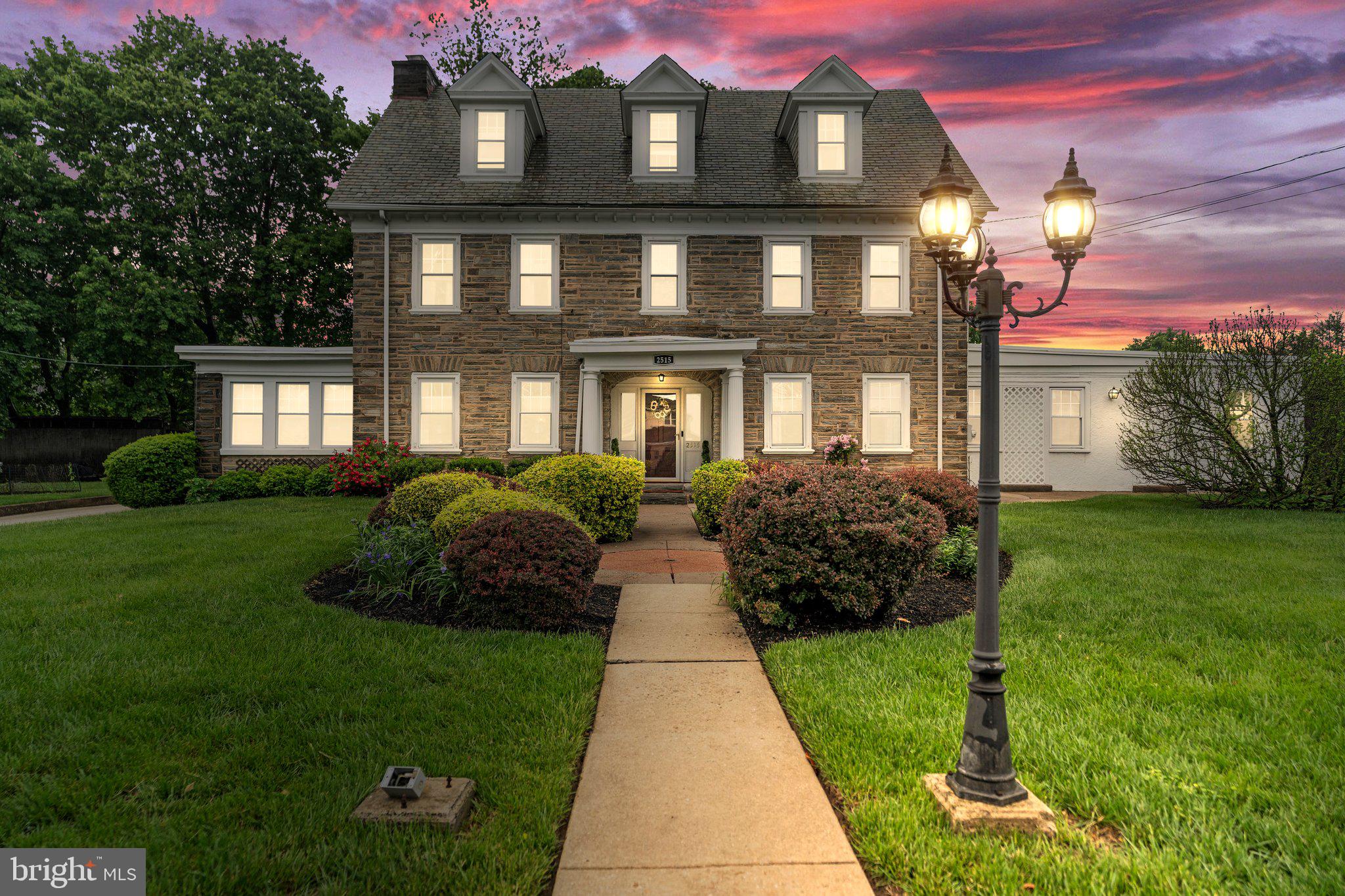 ***Offer Deadline: Monday 6/2 @4pm*** Enjoy the timeless elegance of 2515 Garrett Road, Drexel Hill, PA, a stunning three-story 1920 classic center hall Colonial nestled on three expansive lots. This distinguished stone residence boasts a blend of historic charm and modern amenities, featuring original parquet wood flooring and intricate moulding. As you enter through the grand center hall, flanked by elegant French doors, you'll be captivated by the formal living area. Here, a stately fireplace, soaring high ceilings, and an adjacent office or den create an atmosphere of sophistication and comfort.
The formal dining room exudes charm with its built-in shelving and a sparkling crystal chandelier, ideal for hosting elegant gatherings. The family room, a haven of relaxation, features a wet bar, wine fridge, a convenient half bath, and access to the expansive private yard. Culinary enthusiasts will revel in the gourmet eat-in kitchen, adorned with luxurious granite counters and sleek black stainless appliances.
The second and third floors reveal five generously sized bedrooms and three tastefully updated bathrooms. The refined primary suite offers a sanctuary of modern comfort, complete with a walk-in shower, soaking tub, and dual sinks. Outside, a private landscaped yard with a paver patio provides an idyllic setting for entertainment and relaxation. The property also includes a two-car carport and zoning to return to its former use as a doctor's in-home office, enhancing its versatility. A very rare opportunity in Drexel Hill to acquire 2 additional lots offering privacy, tons of outdoor space & ample parking. With seamless access to Center City, the airport, and the Main Line, this distinguished home combines historic elegance with modern convenience.