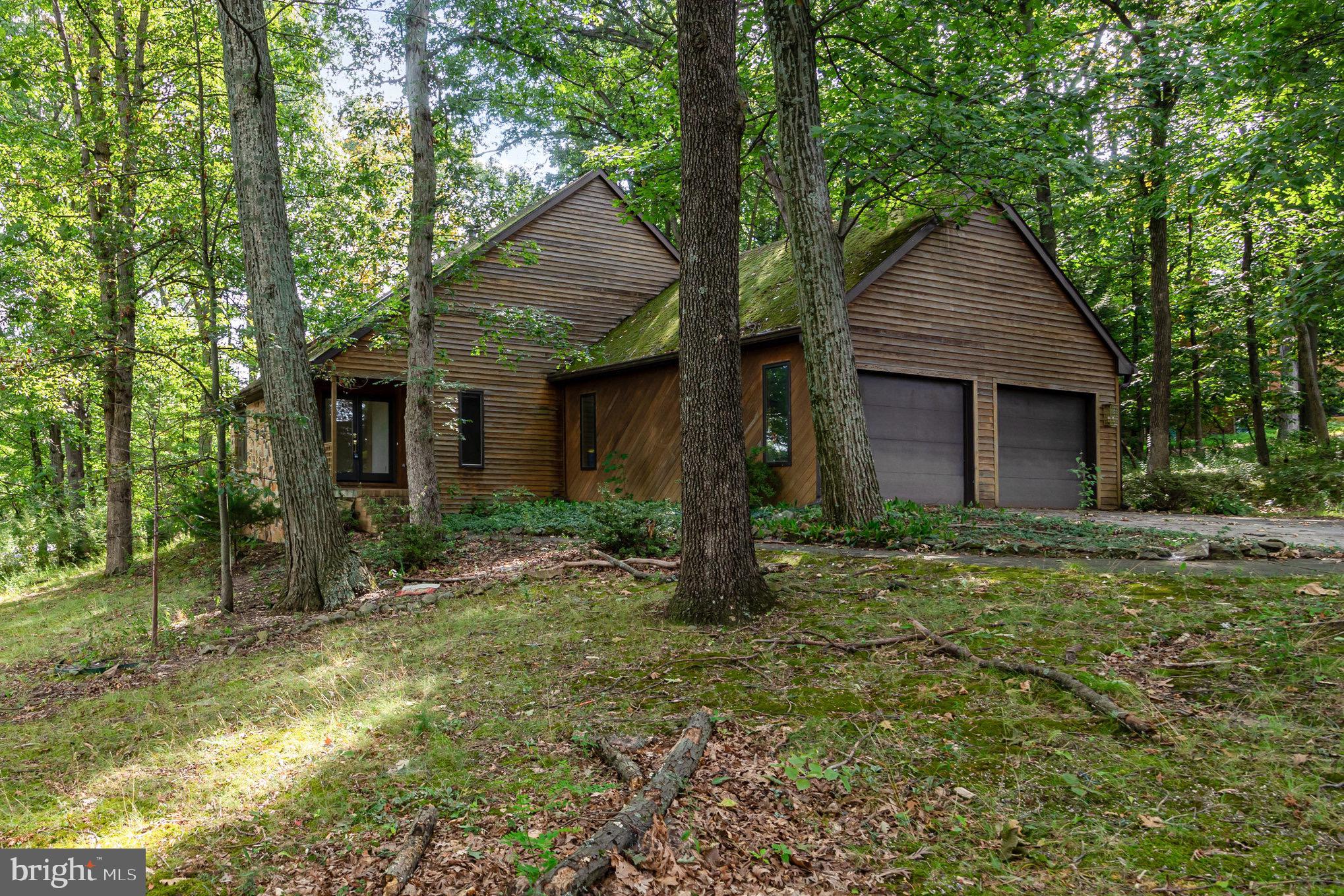 Gorgeous contemporary home tucked away on a wooded corner lot in Fairview Township, West Shore Schools. This home features a open floorplan and plenty of natural light. Walk in the foyer to the open, sunken two-story living room, look up to the loft that could be your office or sitting room.
The two-sided gas fireplace warms both the living area and dining room. Imagine entertaining and the ambience. Beautiful Spacious Kitchen with Breakfast Bar (dated, but gorgeous) The first floor features 3 bedrooms and full bath, a powder room for guests, first floor laundry with a laundry tub, plus a large family room separate and private from the formal entertaining space. Retire to the back family room to watch the wildlife come awake or sit on the patio with a beverage and a fire. Plus an oversized 2 car garage. The second-floor loft overlooks the magnificent first floor and leads to the secluded primary suite. Inside, you will find a primary bedroom with two walk-in closets and a hidden cedar closet and a private balcony (needs replaced). A primary bathroom fit for a King; a corner jetted tub, private toilet and bodea, 2 large vanities, and large shower for two. Don't miss your chance to own this one-of-a-kind property and make it your own. It would be Perfect for an Air B&B too. Close to Ski Roundtop, Yellow Breeches, Pinchot Park, Hershey Park. So Many Possibilities. We do have an appraisal at $489K. This Home is Priced to Sell. Motivated Seller